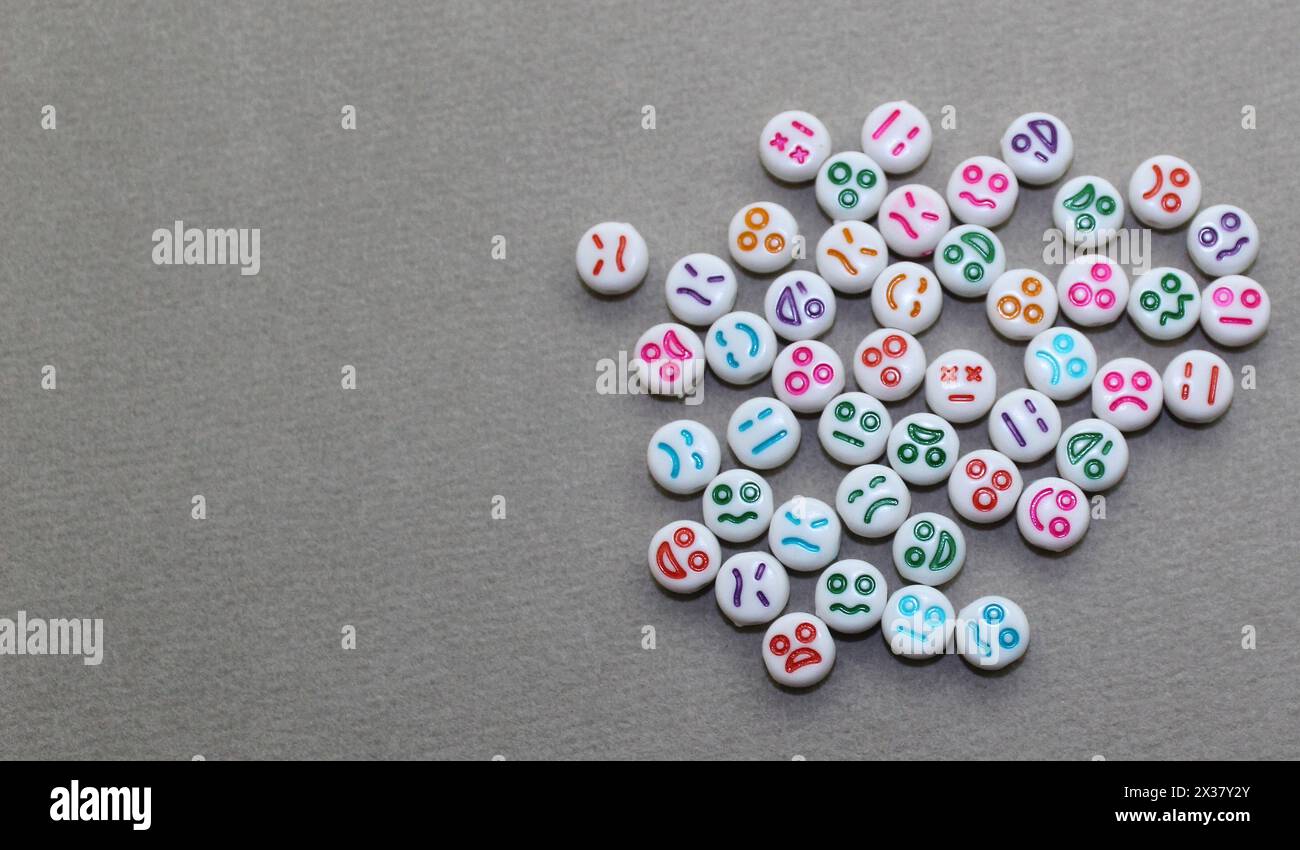 Dekorative Kunststoffperlen mit lustigen Gesichtern. Weiße Ziersteine für die Halskette. Stockfoto