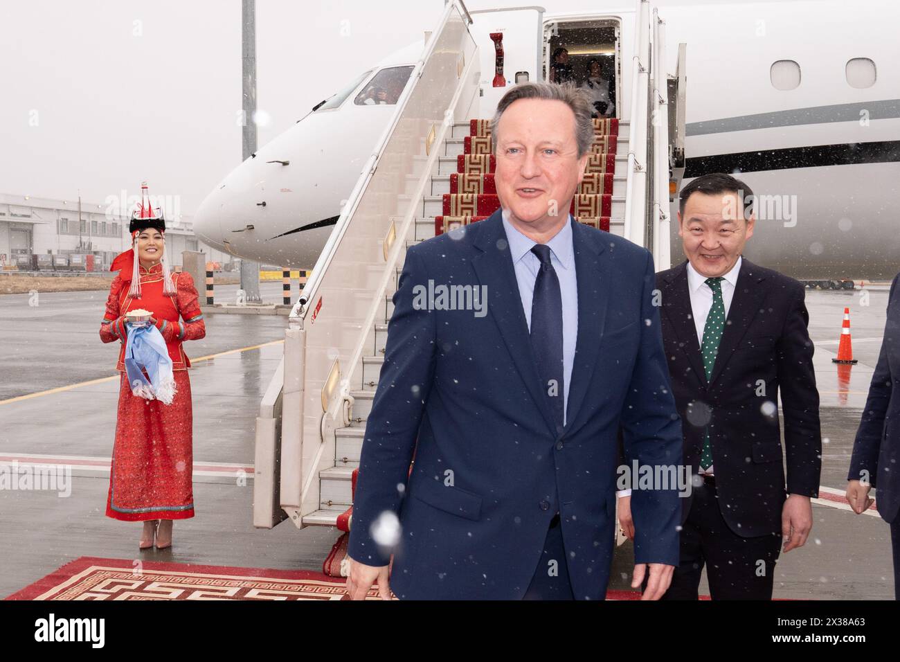 Außenminister Lord David Cameron kommt im Schnee auf dem Flughafen Chinggis Khan in Ulaanbaatar, Mongolei, während seiner fünftägigen Tour durch Zentralasien an. Bilddatum: Donnerstag, 25. April 2024. Stockfoto