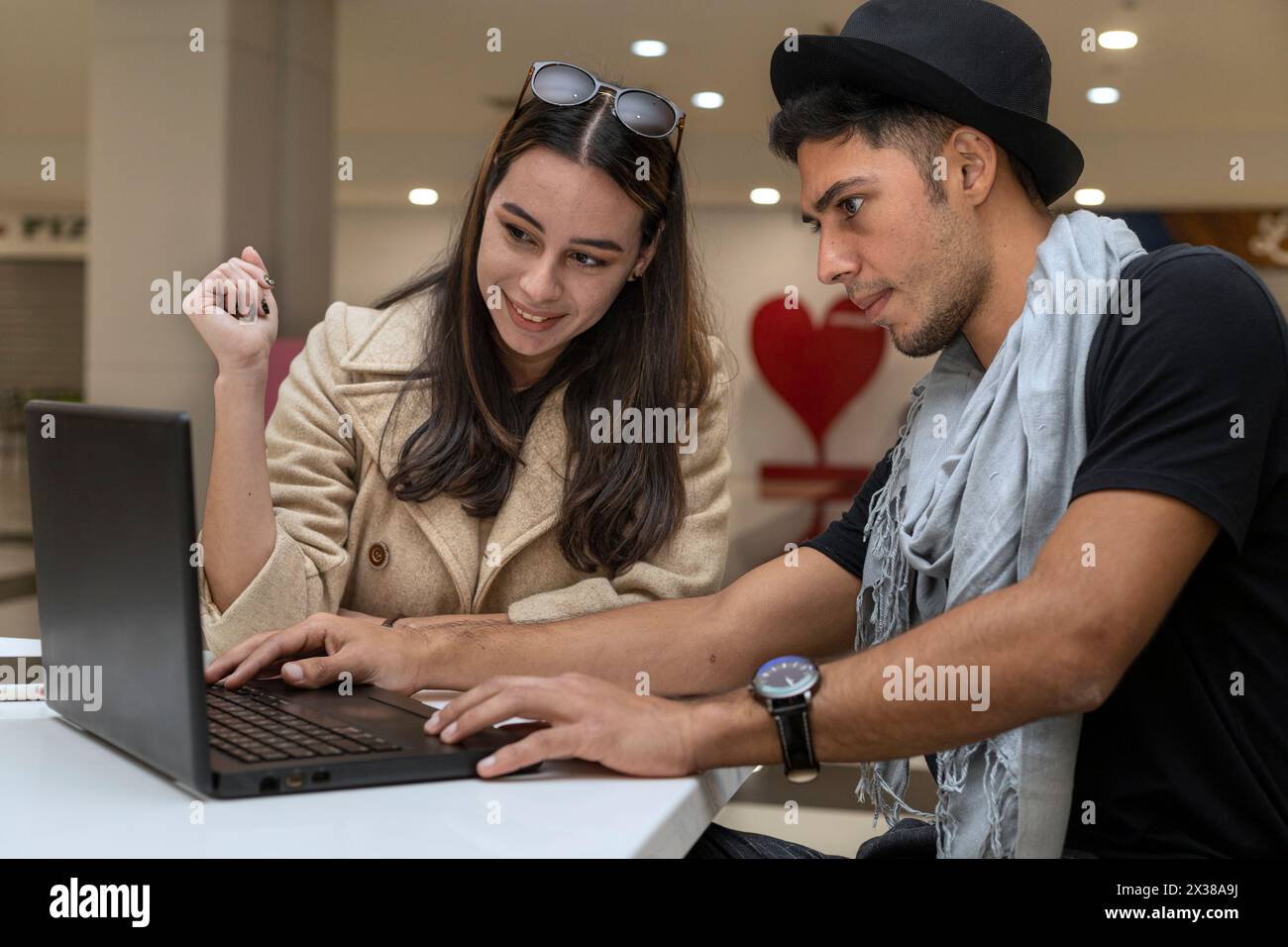 Das junge lateinamerikanische Touristenpaar, das online einkaufen will. Konzept für Online-Shopping, Tourismus Stockfoto