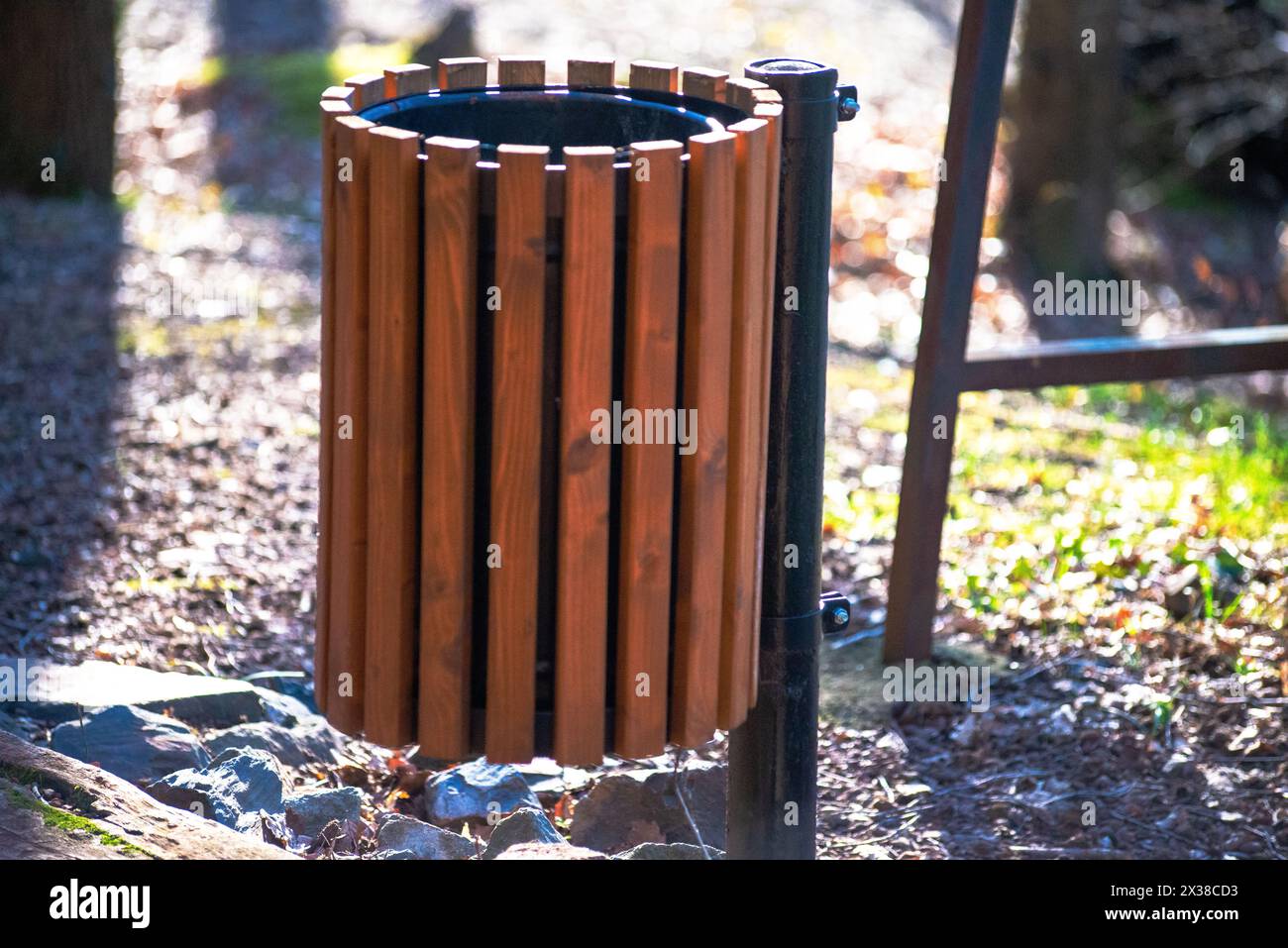 Ein Abfallkorb, der entlang der Laufstraße im Wald platziert wird, fördert Sauberkeit und Umweltschutz. Stockfoto