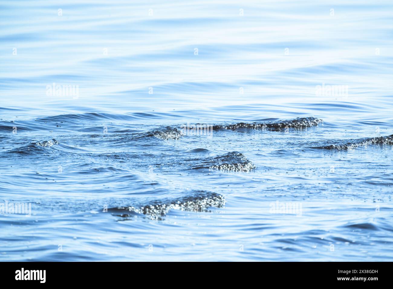 Blaue Meerwasseroberfläche mit kleinen Wellen, natürliches Hintergrundfoto Stockfoto