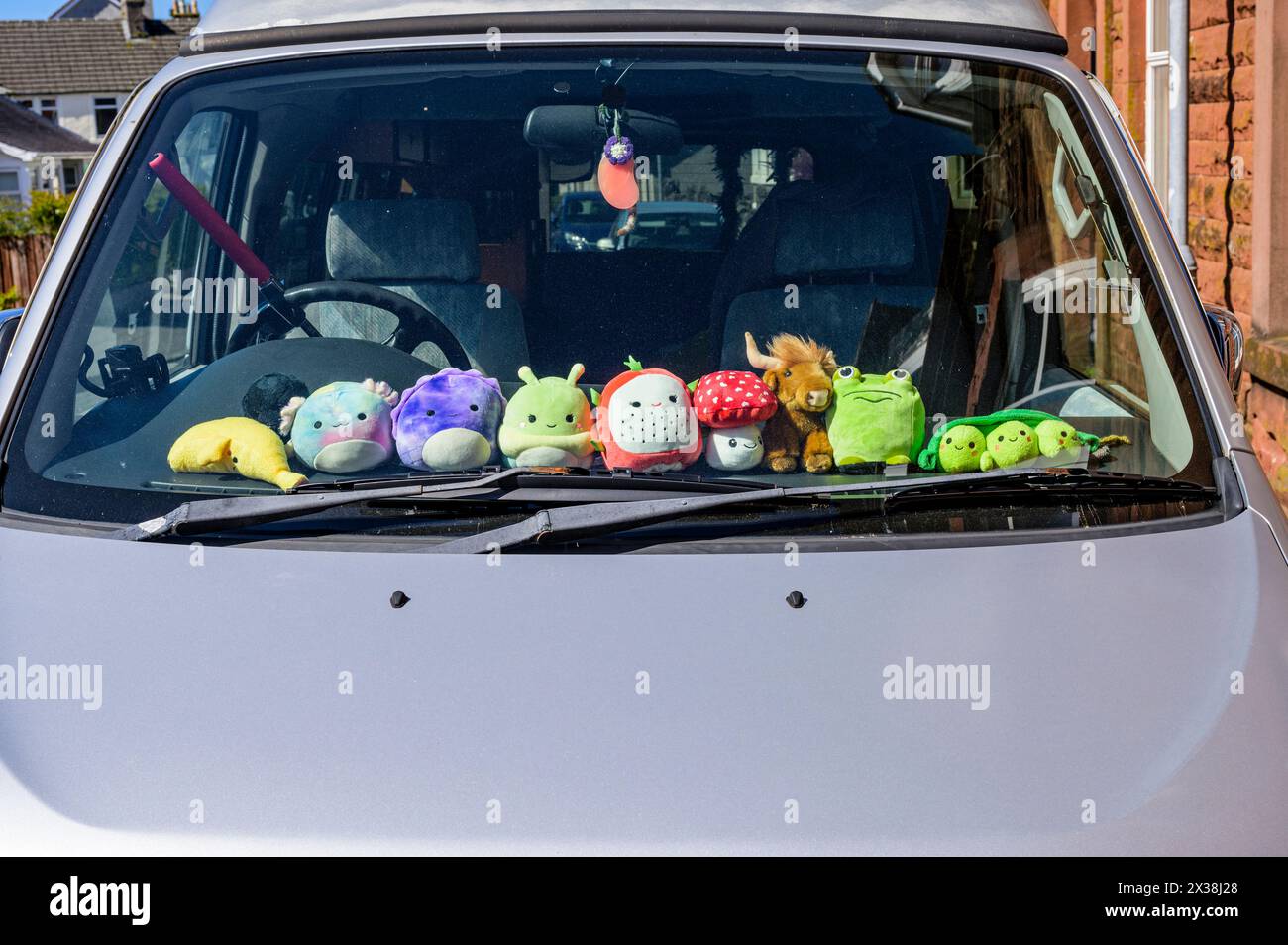 Weiche Spielzeuge auf dem Armaturenbrett eines geparkten Autos Stockfoto