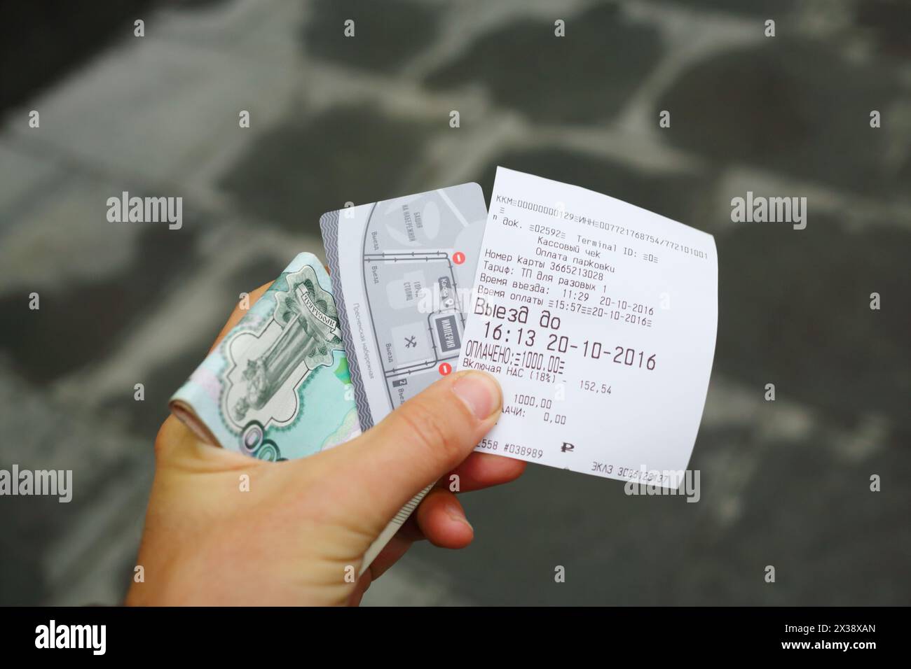 MOSKAU - 20. OCT 2016: Männliche Hand hält ein Ticket für den Parkplatz im Empire Tower in Moskau City, Geld und Plastikkarte Stockfoto