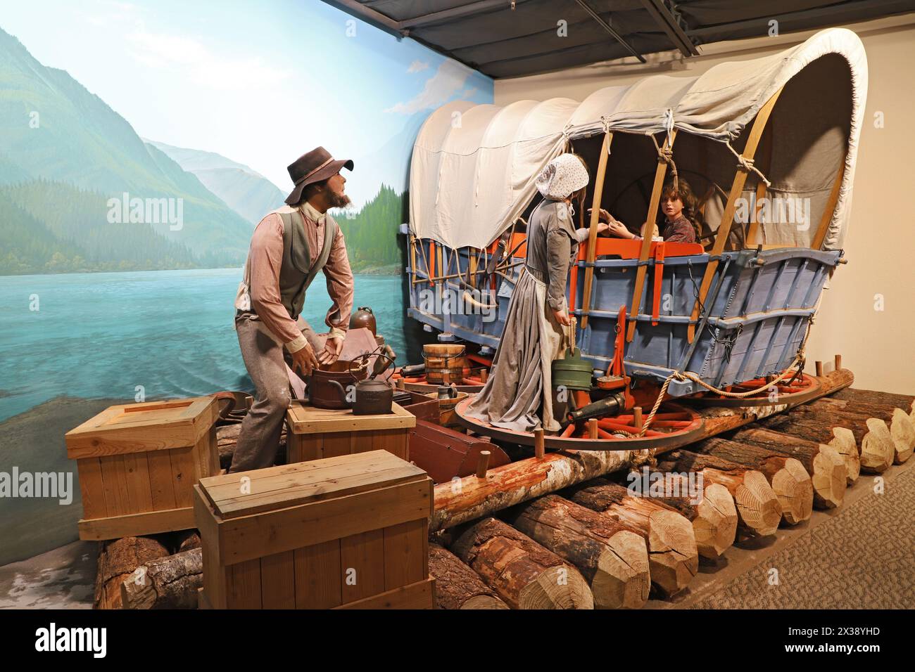 Lebensgroßes Modell eines Conestoga-Wagens und einer Familie, die den Columbia River befahren, nachdem sie den Oregon Trail von den östlichen Vereinigten Staaten aus befahren haben, 1851. Stockfoto