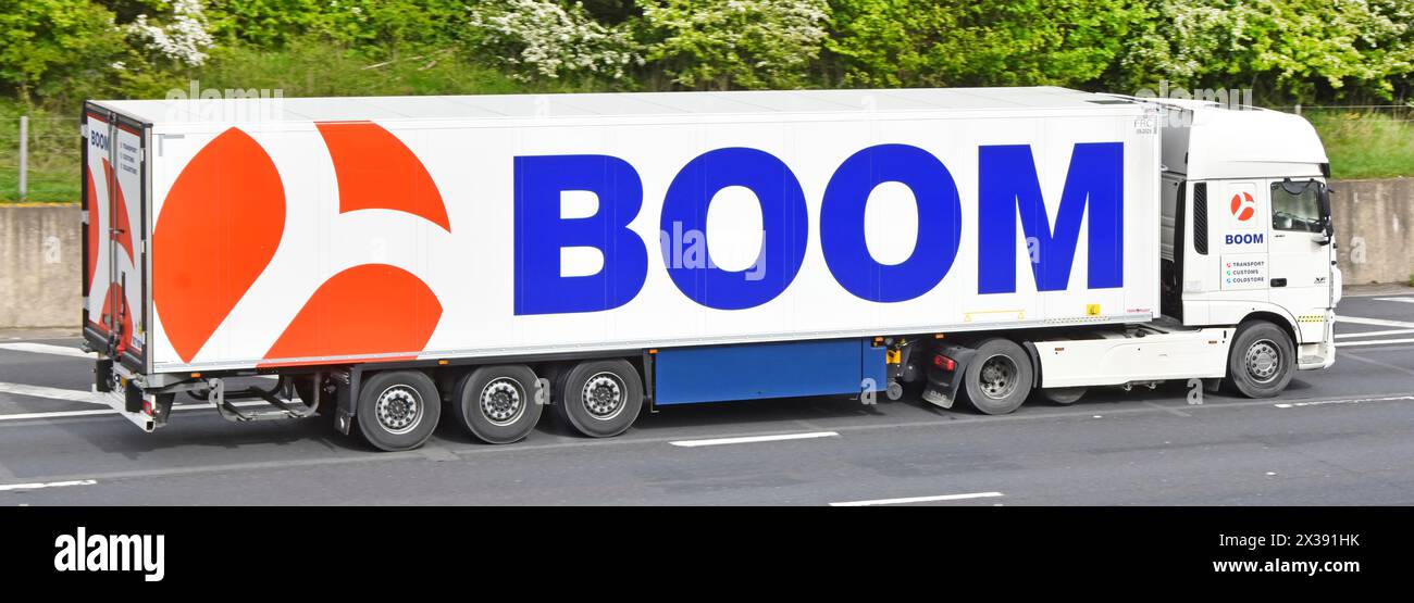 Transportunternehmen, weiß, Lkw-Lkw-Lkw-Lkw-Lkw und Auflieger, rotes übergroßes Logo und auffällige blaue BOOM-Werbung, die auf der M25autoway UK fährt Stockfoto