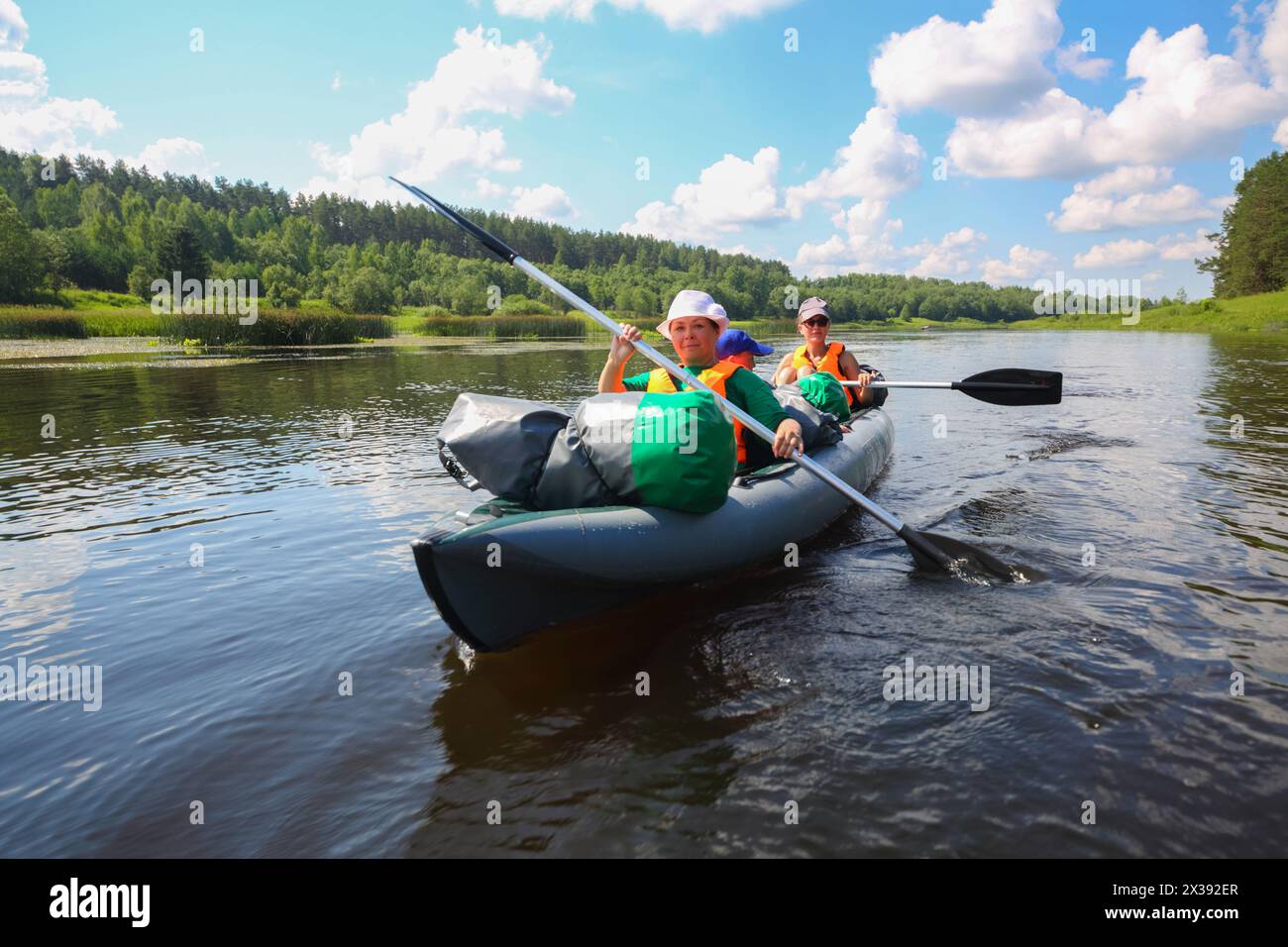 Zwei Frauen und ein kleiner Junge segeln an sonnigen Sommertagen auf Schlauchbooten auf dem Fluss Stockfoto