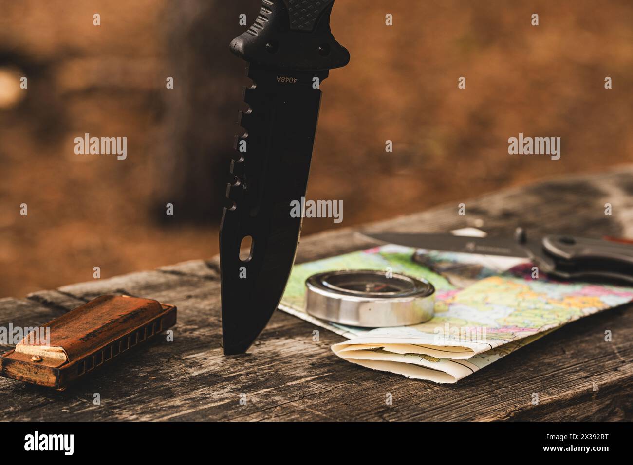 Survival- und Outdoor-Freizeitausrüstung, Messer, Kompass, Karte und Mundharmonika Stockfoto