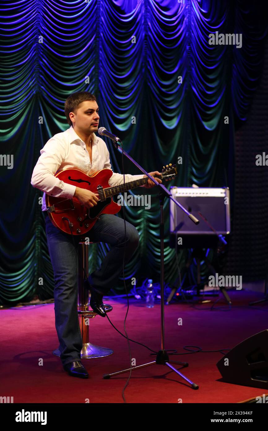 Sänger singt und spielt Gitarre im Jazzclub Stockfoto