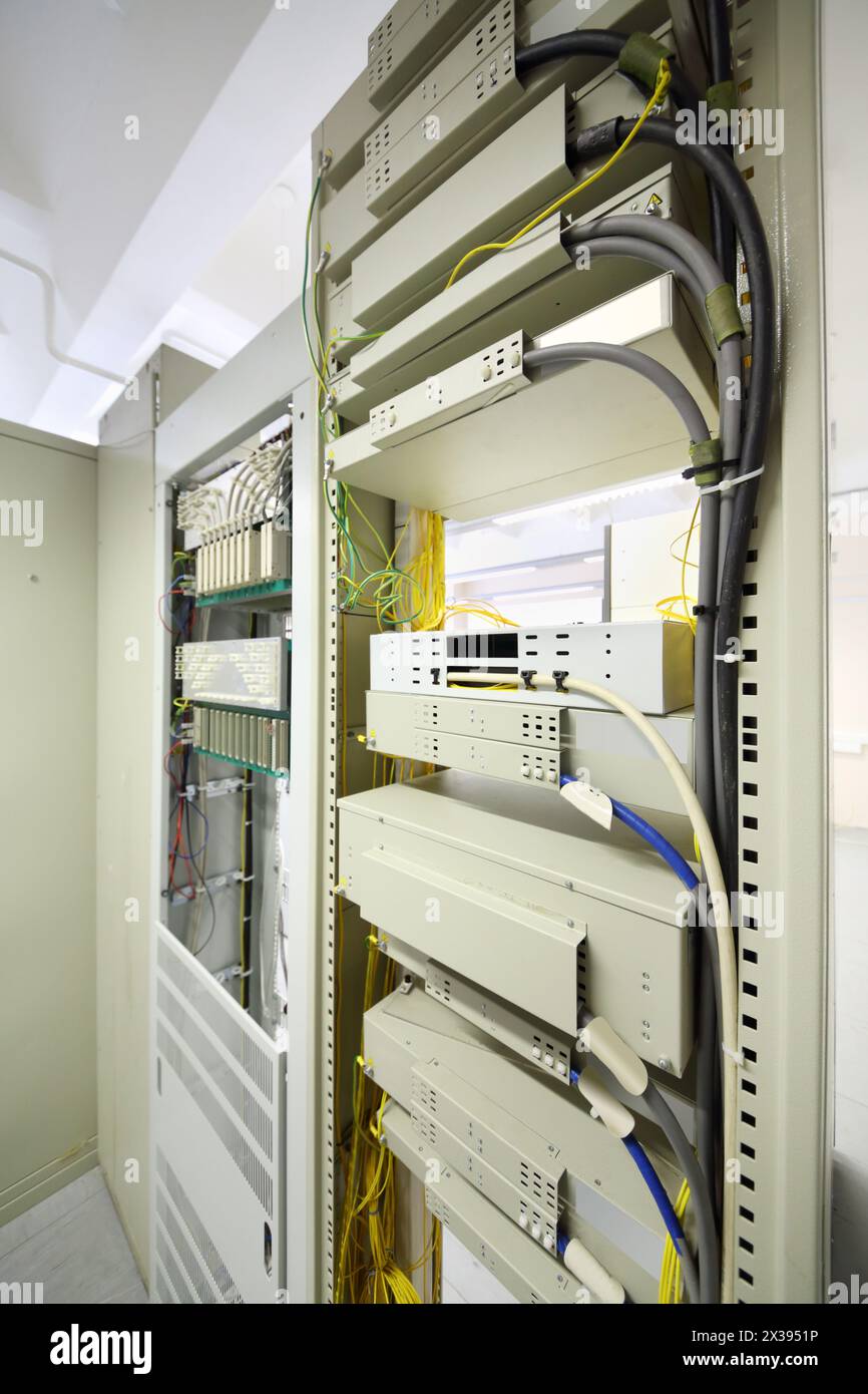 Telekommunikationsgeräte mit Kabeln und Schaltern im Kommunikationszentrum Stockfoto
