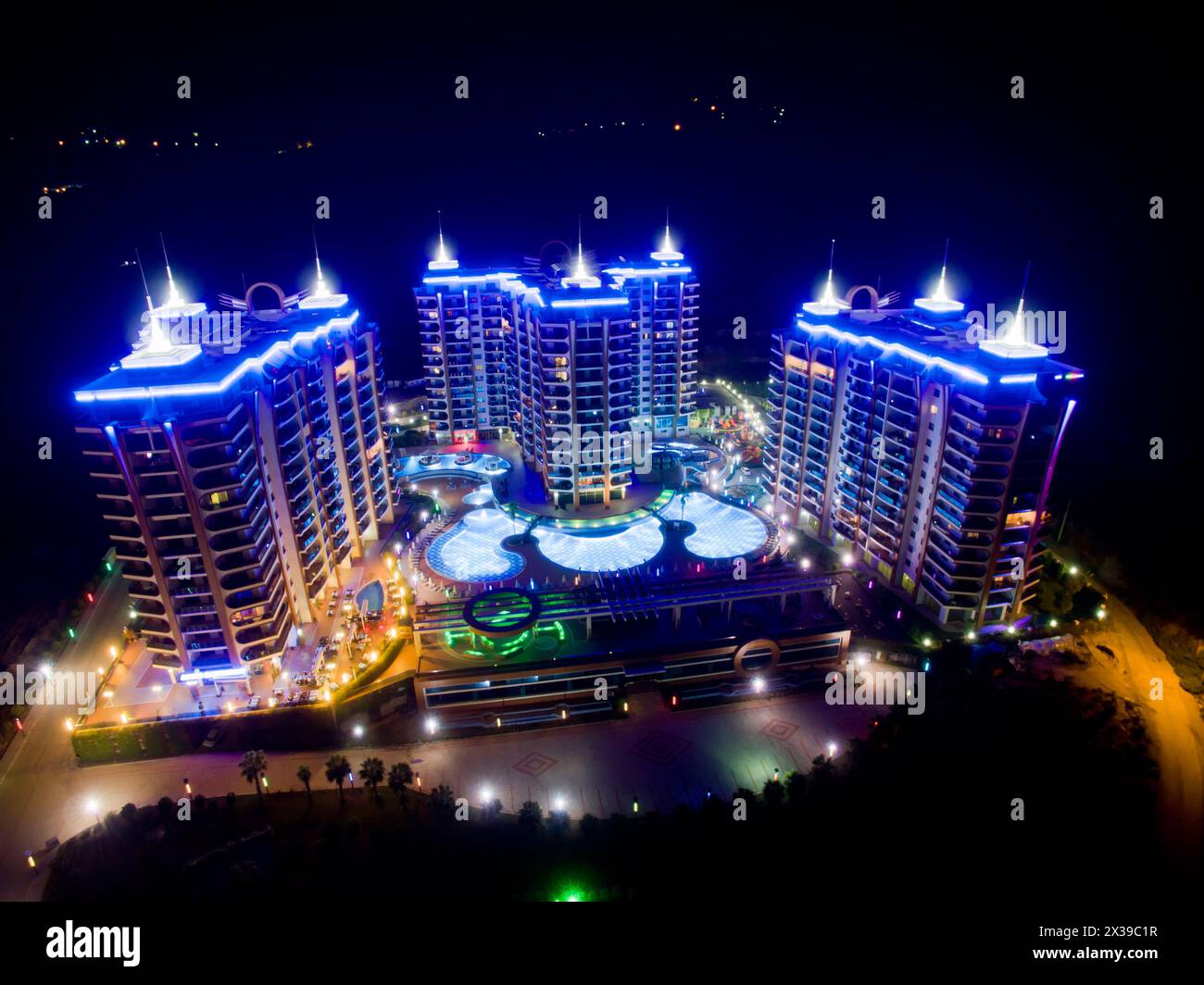 ALANYA, TÜRKEI - 16. August 2015: Drei Gebäude des Apartmentkomplexes Azura Park Residence mit Farblicht bei Nacht, Luftbild Stockfoto