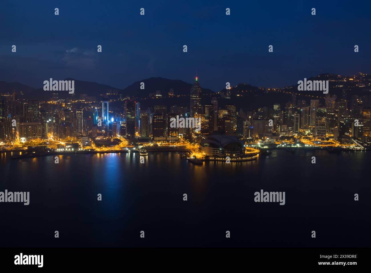 Wolkenkratzer mit heller Beleuchtung, Ufer und Berge in Hongkong, China bei dunkler Nacht, Blick vom New World Center Stockfoto