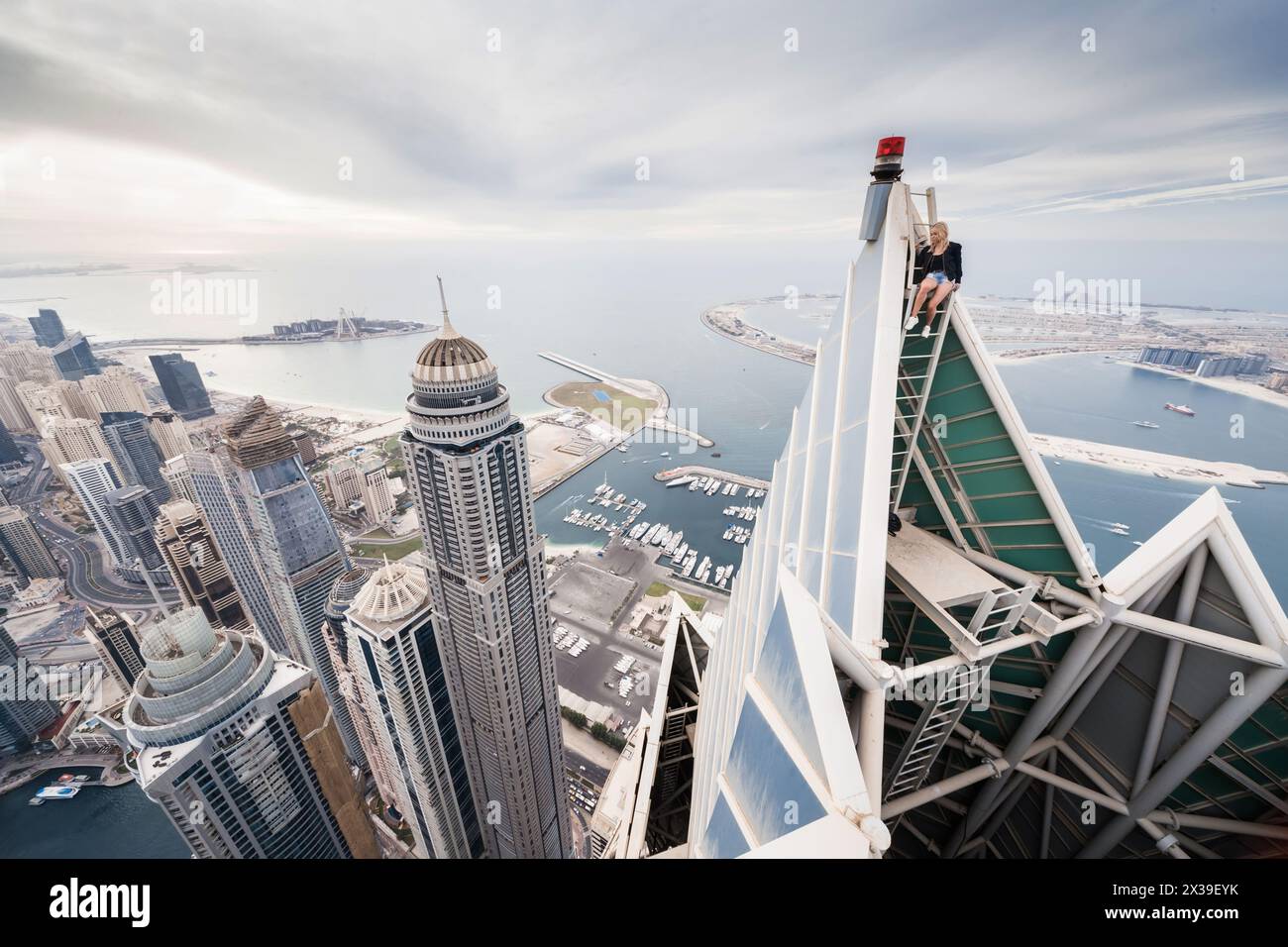 DUBAI, VAE - 15. JAN 2017: Prinzessin Tower, Dubai Marina Area, Frau sitzt auf dem Dach der Marina 101 Stockfoto