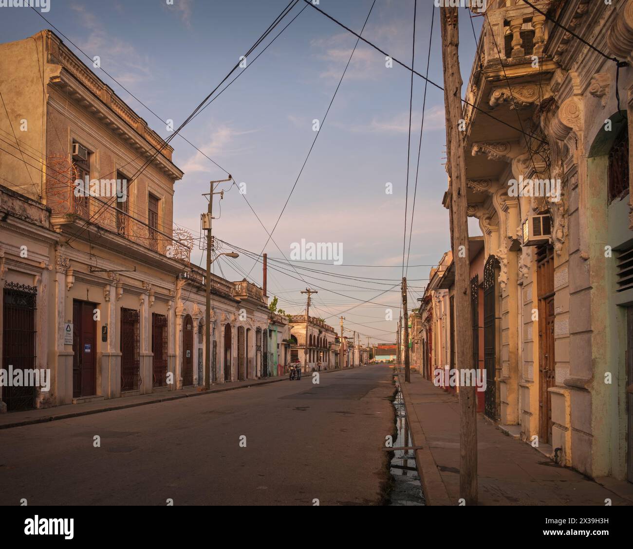 Blick auf eine verlassene Straße in der Innenstadt von Cienfuegos, Kuba, kurz vor Sonnenaufgang. Stockfoto