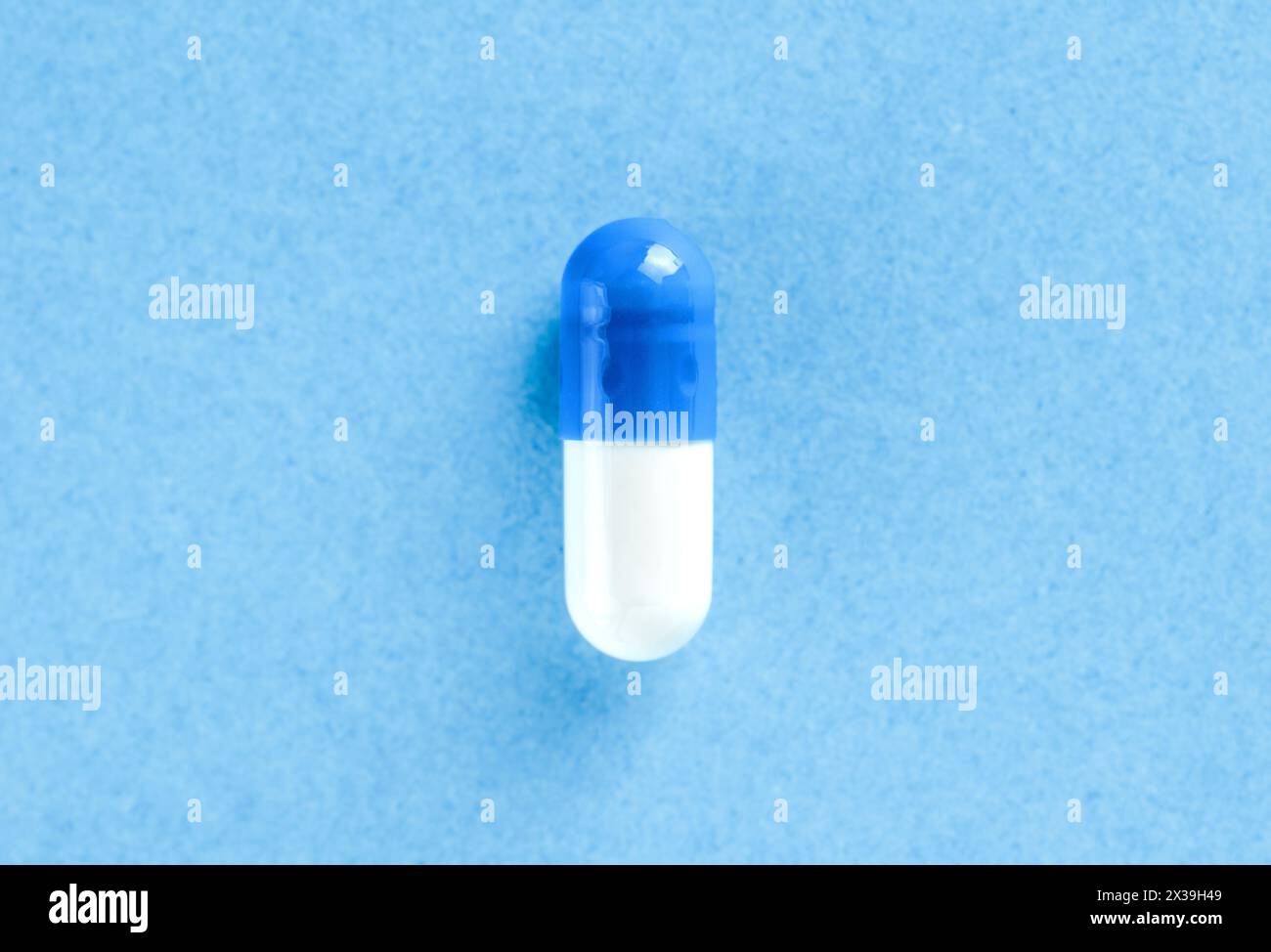 Weiße und blaue pharmazeutische Pille. Medizinische Kapsel. Tablet auf blauem Hintergrund mit Kopierraum. Gesundheitskonzept Stockfoto