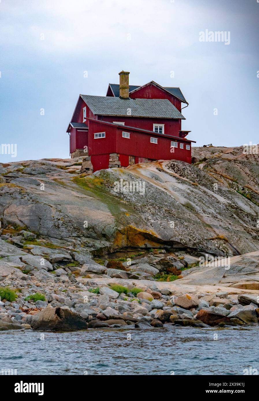 Ansammlung roter Häuser auf einer kleinen Insel für Leuchtturm Stockfoto