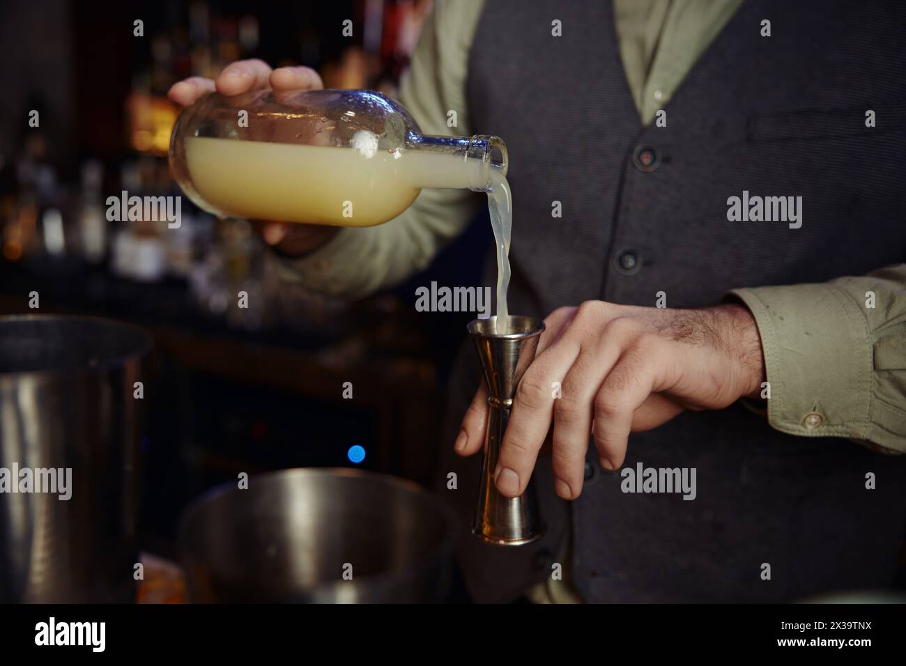 Nahaufnahme eines selbstbewussten Barkeepers, der Alkohol zum Cocktail schmeckt Stockfoto