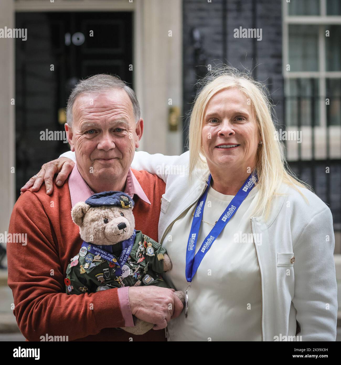 London, Großbritannien. April 2024. Richard Bland, Gründer Bear Force, mit dem Bärenmaskottchen, und Sara Williams, CEO von Kids Out. Die Wohltätigkeitsorganisationen Bear Force und Kids Out haben heute Nachmittag einen Fotoanruf an der berühmten schwarzen No 10 Door in der Downing Street. Bear Force wurde gegründet, um Kinder jeden Alters zum Reden zu ermutigen, nach dem Selbstmord des Gründers Richard Bland Sohn. Kids Out ist eine Wohltätigkeitsorganisation, die Kinder und Mütter unterstützt, die in 650 Schutzhütten leben. Kinder, die Opfer von Misshandlungen und Traumata geworden sind, wollen das Leben der Kinder wieder glücklich machen. Quelle: Imageplotter/Alamy Live News Stockfoto