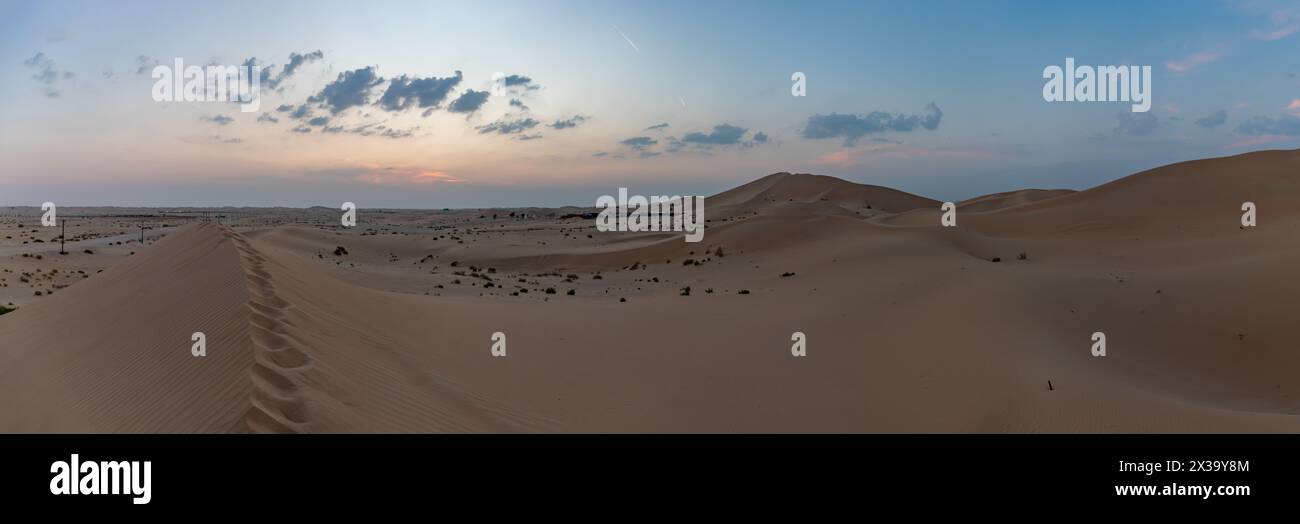 Ein Panoramabild der Wüstenlandschaft außerhalb von Abu Dhabi bei Sonnenuntergang. Stockfoto