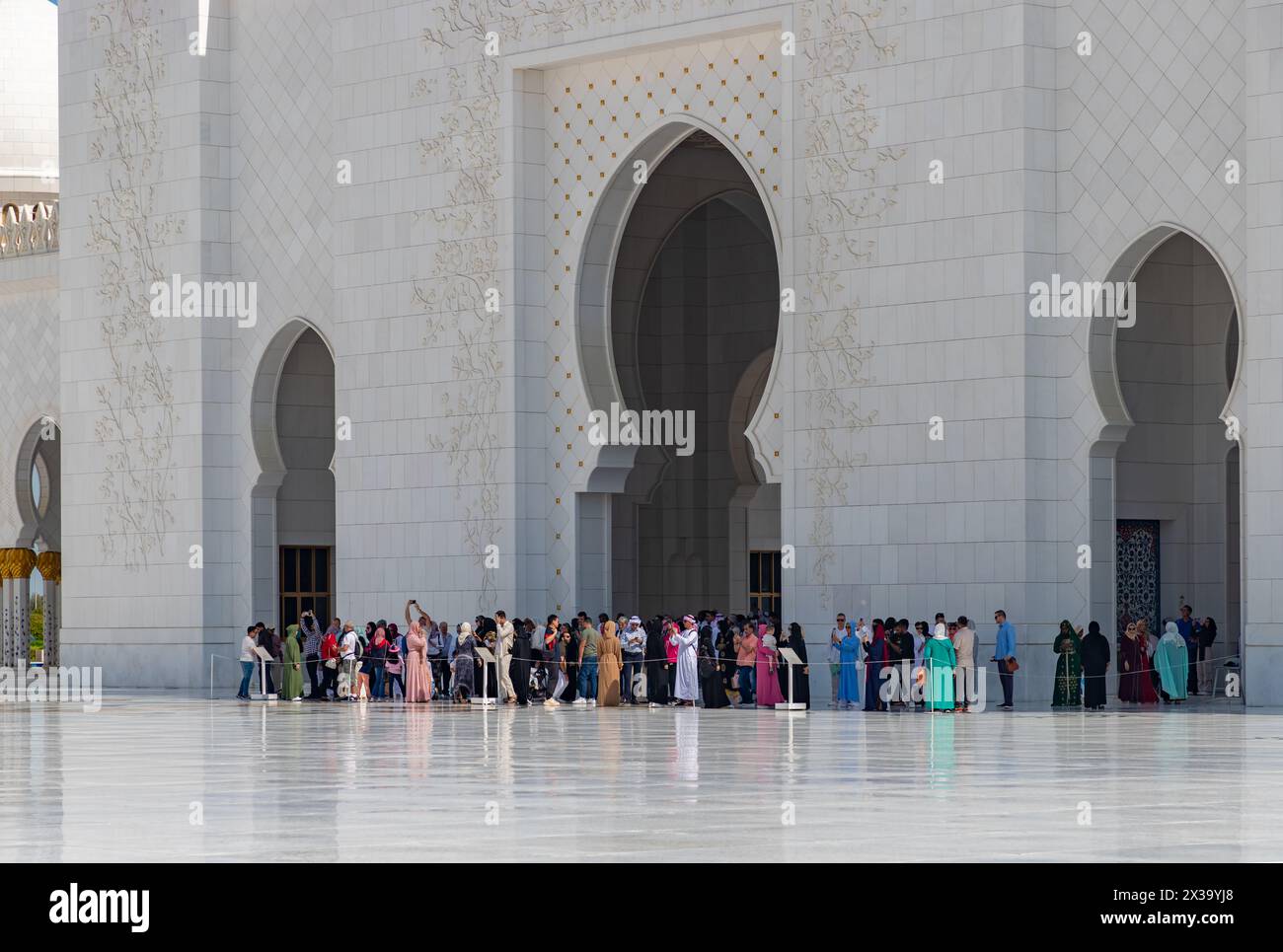 Ein Bild des Sahan Courtyard der Scheich-Zayed-Moschee mit einer großen Besuchermenge in der Nähe des Eingangs. Stockfoto