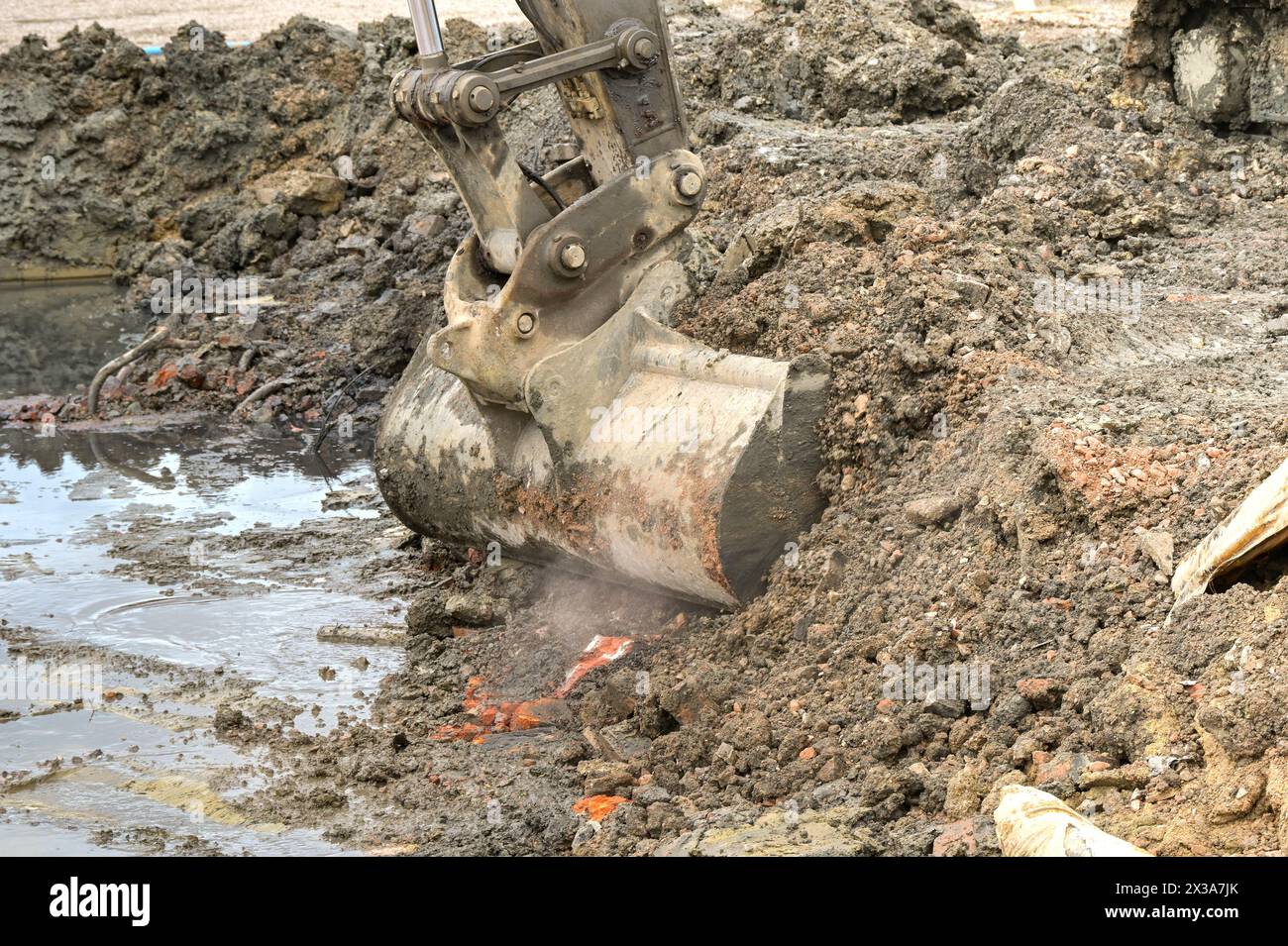Schaufel eines Baggers, der Erde und Schutt auf einer Baustelle aufnimmt. Keine Personen. Stockfoto