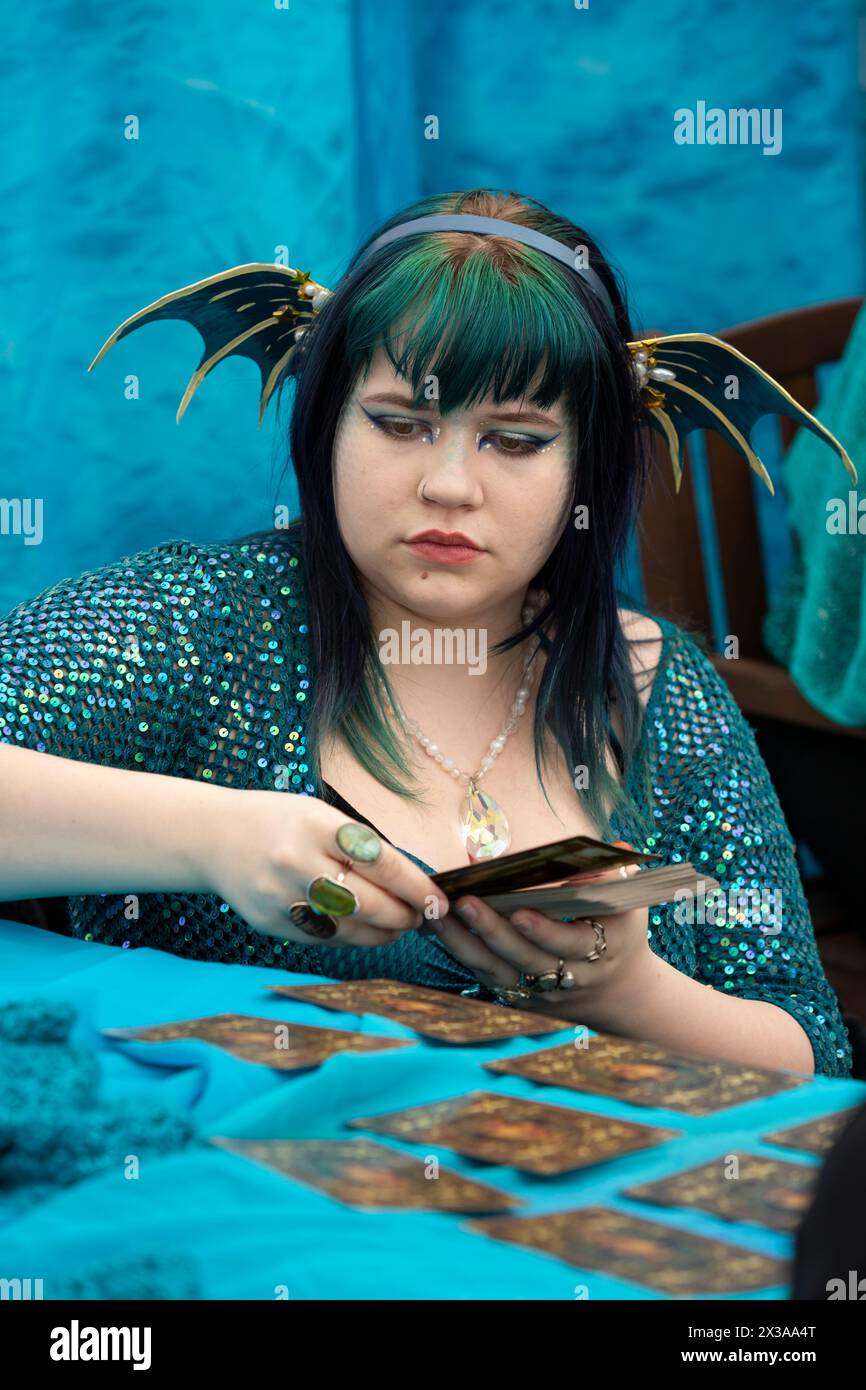 Eine als Sirene gekleidete junge Frau liest Tarotkarten für einen Besucher während des Meerjungfrauenfestes im International Mermaid Museum in Aberdeen, Washingt Stockfoto