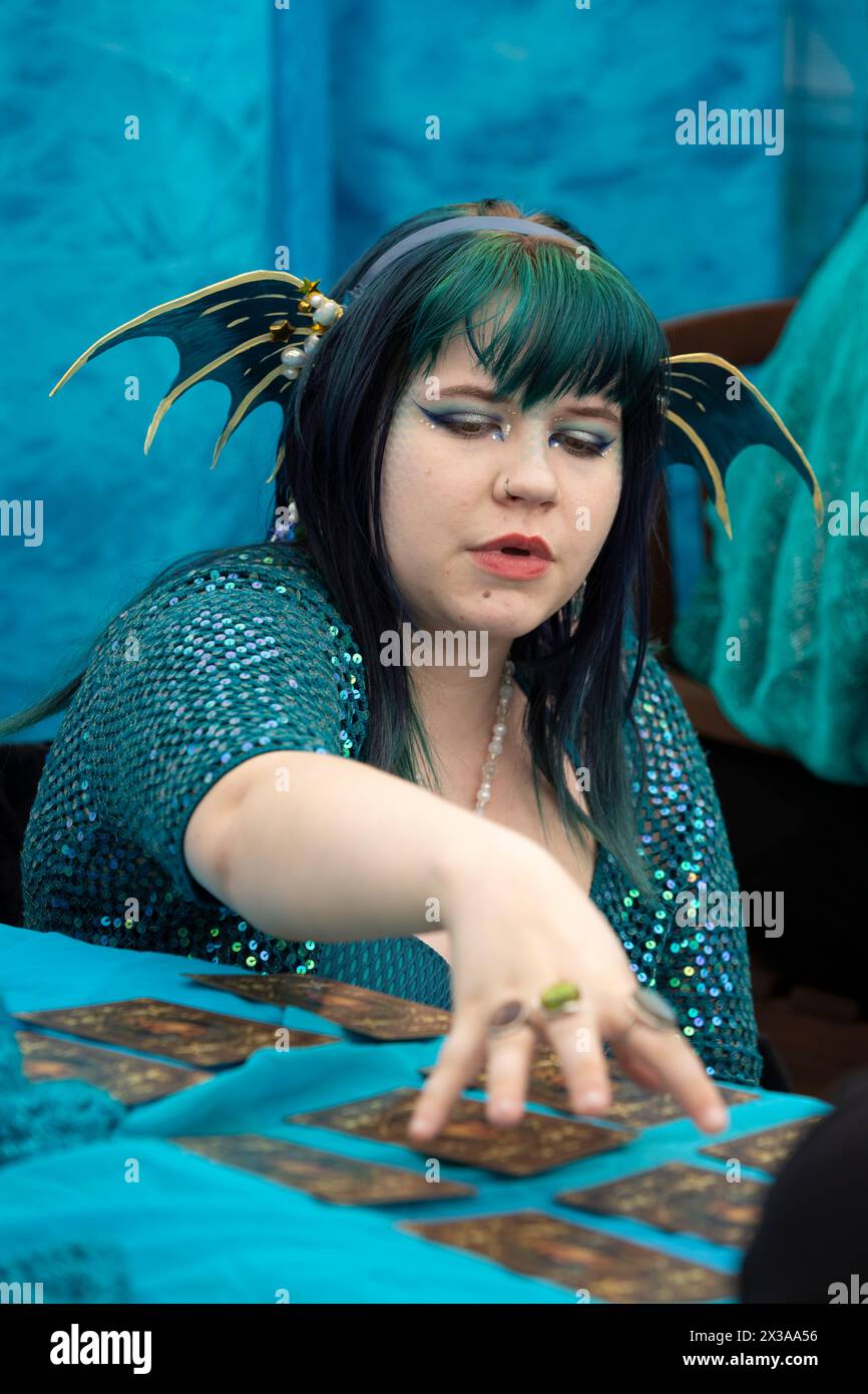 Eine als Sirene gekleidete junge Frau liest Tarotkarten für einen Besucher während des Meerjungfrauenfestes im International Mermaid Museum in Aberdeen, Washingt Stockfoto