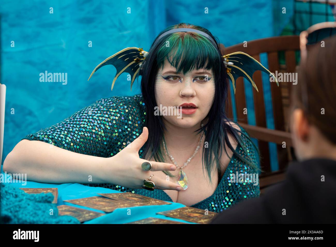 Eine als Sirene gekleidete junge Frau liest Tarotkarten für einen Besucher während des Meerjungfrauenfestes im International Mermaid Museum in Aberdeen, Washingt Stockfoto
