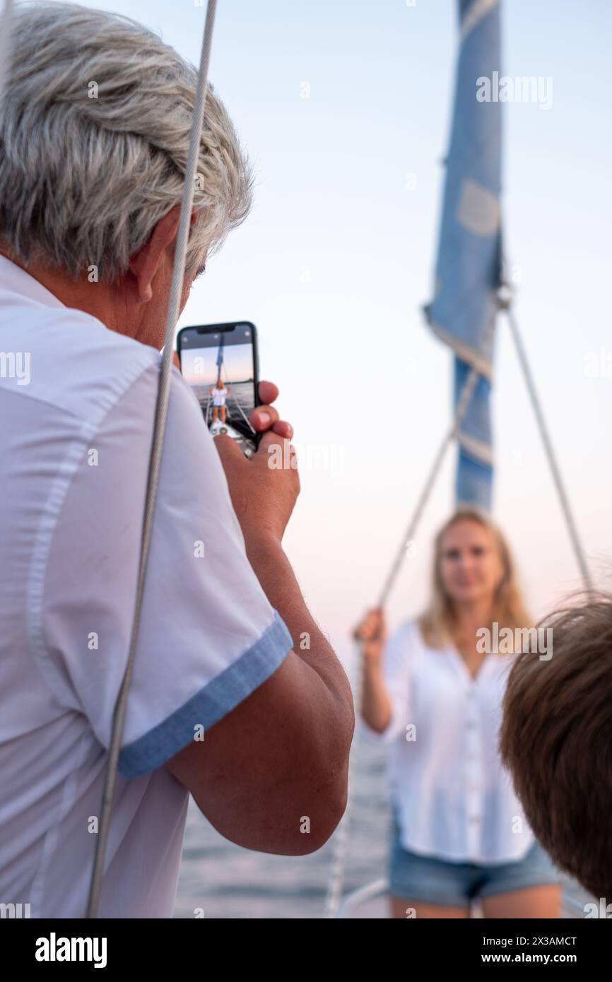 Silberhaariger individueller Fotopartner auf einem Smartphone, eine heitere Darstellung von Modernität und Verbindung in späteren Jahren. Hochwertige Fotos Stockfoto