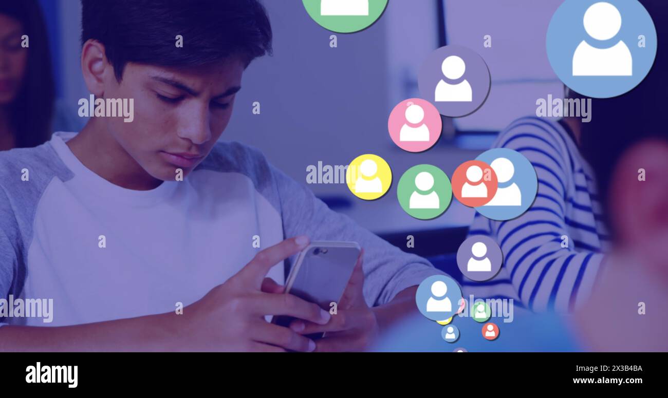 Bild von Social-Media-Ikonen über dem Schuljungen, der während des Unterrichts ein Smartphone verwendet Stockfoto