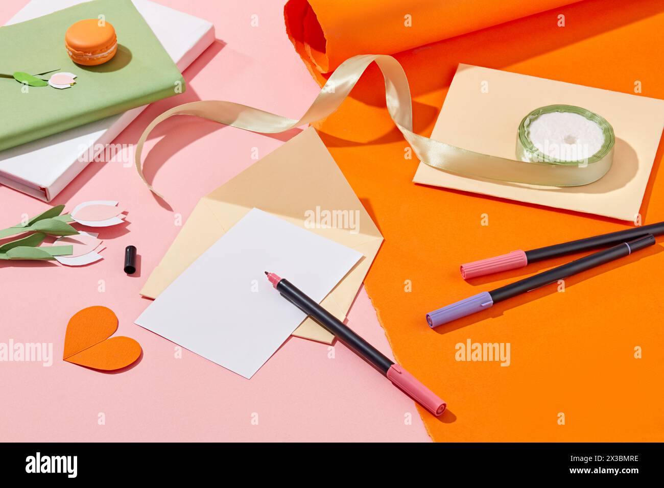 Mehrere Farbmarkierungen werden mit einem leeren Blatt Papier und Umschlägen angezeigt. Ein Stapel von Notizbüchern mit einer Rolle Band. Papier geschnitten in Tulpe flo Stockfoto