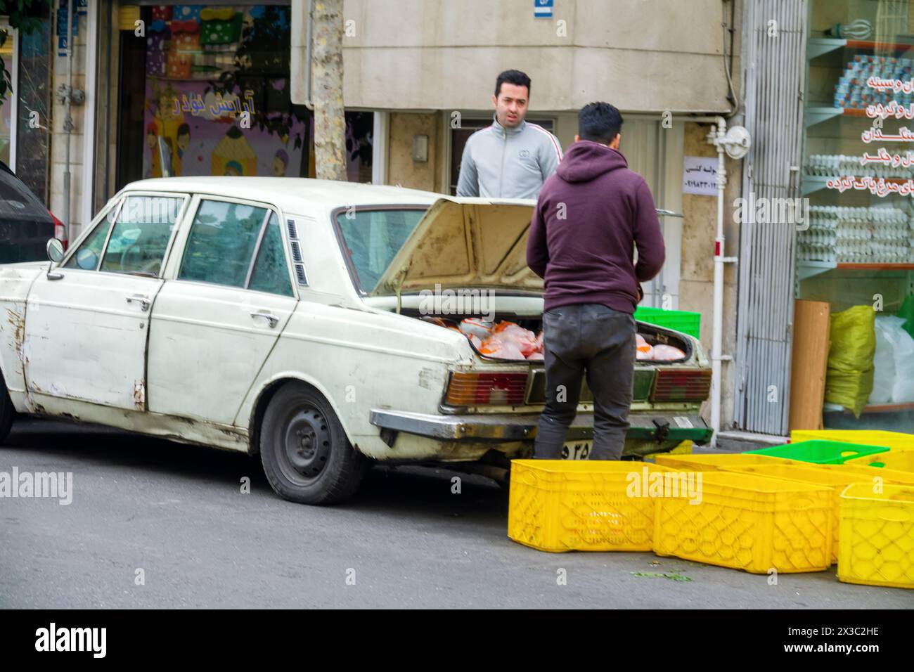 Teheran, Iran, 22. Dezember 2022: Ein altes Auto und die Lieferung von Produkten an kleine Läden, Lieferung von Lebensmitteln direkt vor der Haustür. Feilschen Stockfoto