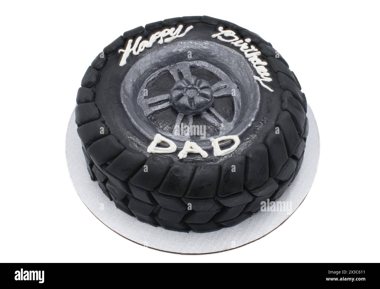 Happy Birthday Dad moderner Designer-Schokoladenkuchen in Form eines schwarzen Autoreifens mit dunklem Fondant als Geländeprofil. Isoliert am Stockfoto