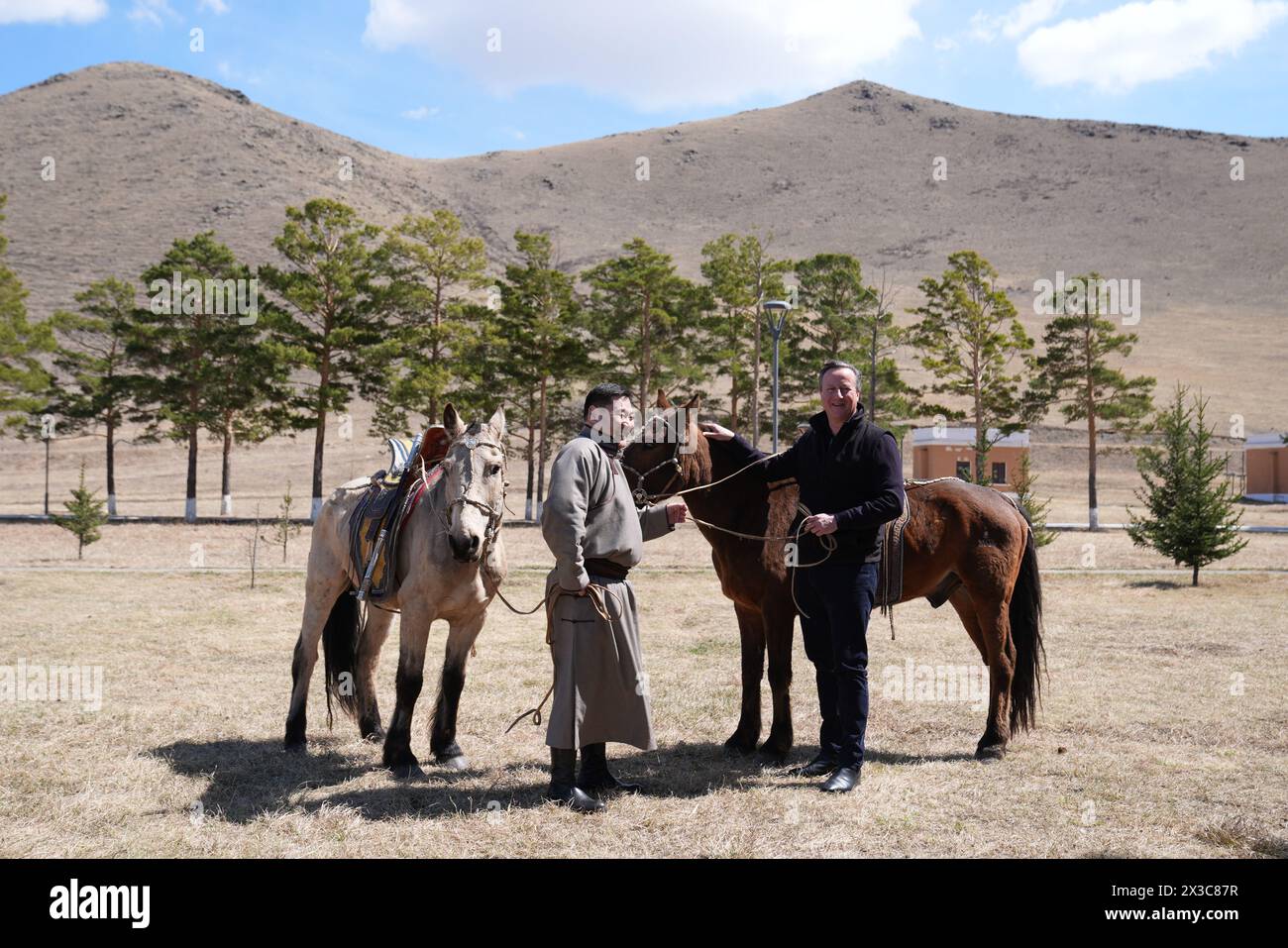 Außenminister Lord David Cameron posiert für ein Foto mit dem Premierminister der Mongolei Oyunerdene Luvsannamsrai und seinen Pferden während eines Besuchs im Ikh Tenger Komplex in Ulaanbaatar, Mongolei, am letzten Tag seiner fünftägigen Tour durch Zentralasien. Bilddatum: Freitag, 26. April 2024. Stockfoto