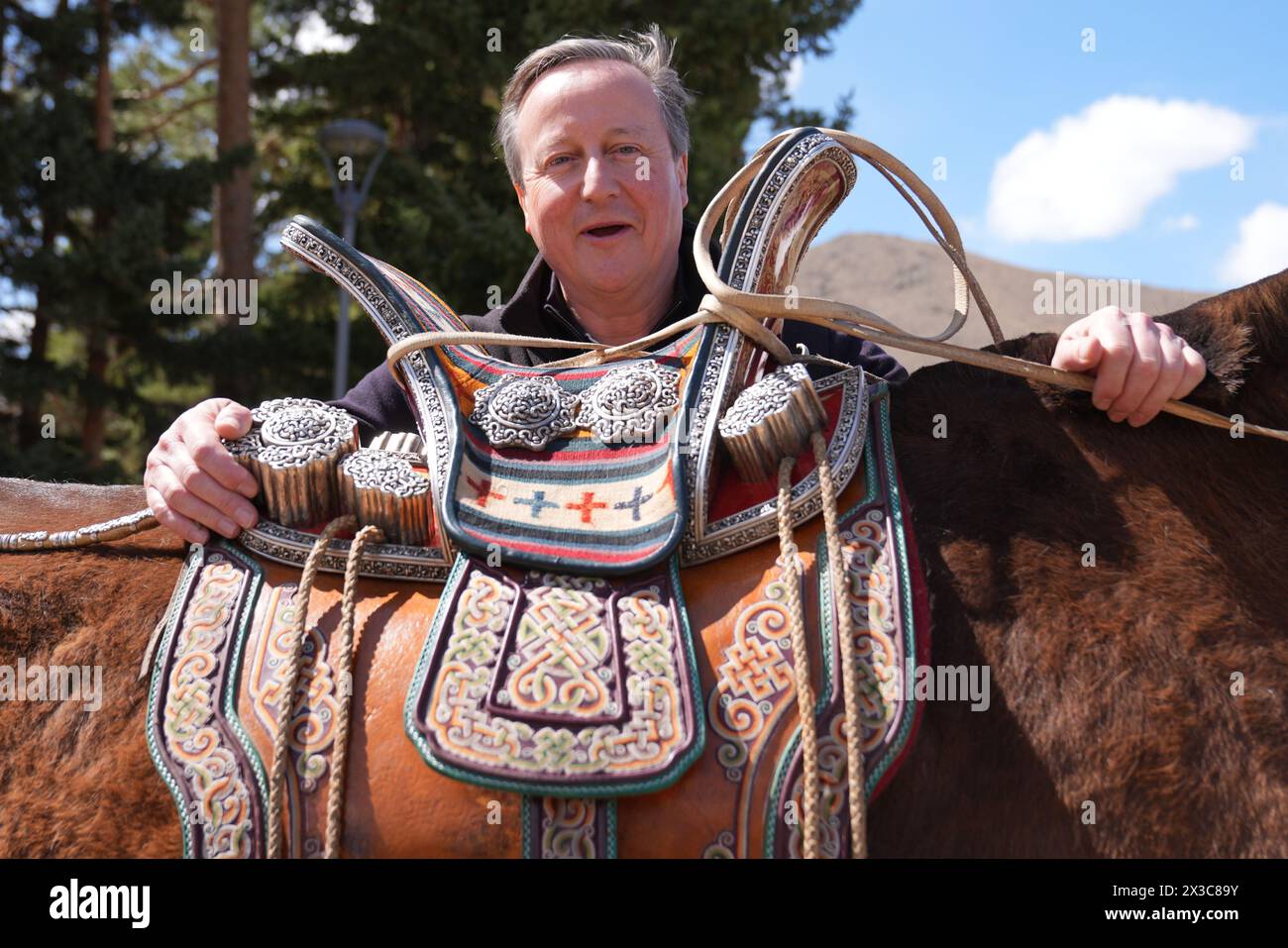 Außenminister Lord David Cameron posiert für ein Foto mit einem der Pferde des Premierministers der Mongolei während eines Besuchs im Ikh Tenger Complex in Ulaanbaatar, Mongolei, am letzten Tag seiner fünftägigen Tour durch Zentralasien. Bilddatum: Freitag, 26. April 2024. Stockfoto