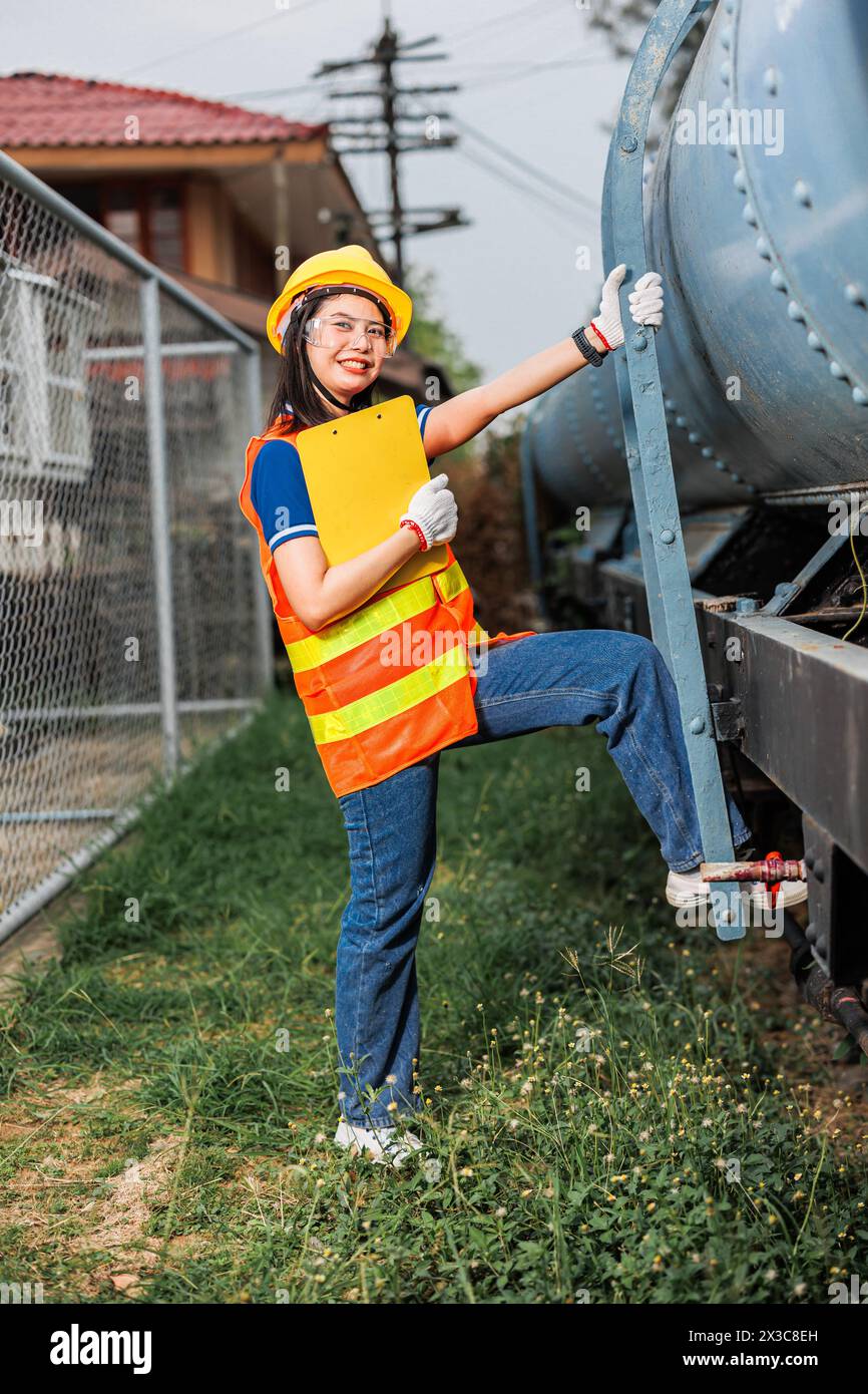 Portrait-Lokomotivingenieur weibliche Arbeiter. Glückliche asiatische junge Teenager lächelnde Arbeit am Bahnhof Bahngleis Lokomotivdienst. Stockfoto