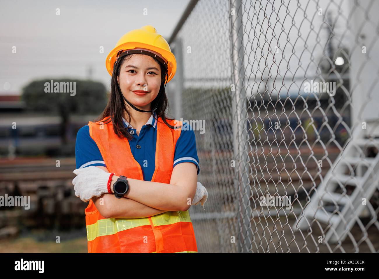 Portrait-Lokomotivingenieur weibliche Arbeiter. Glückliche asiatische junge Teenager lächelnde Arbeit am Bahnhof Bahngleis Lokomotivdienst. Stockfoto