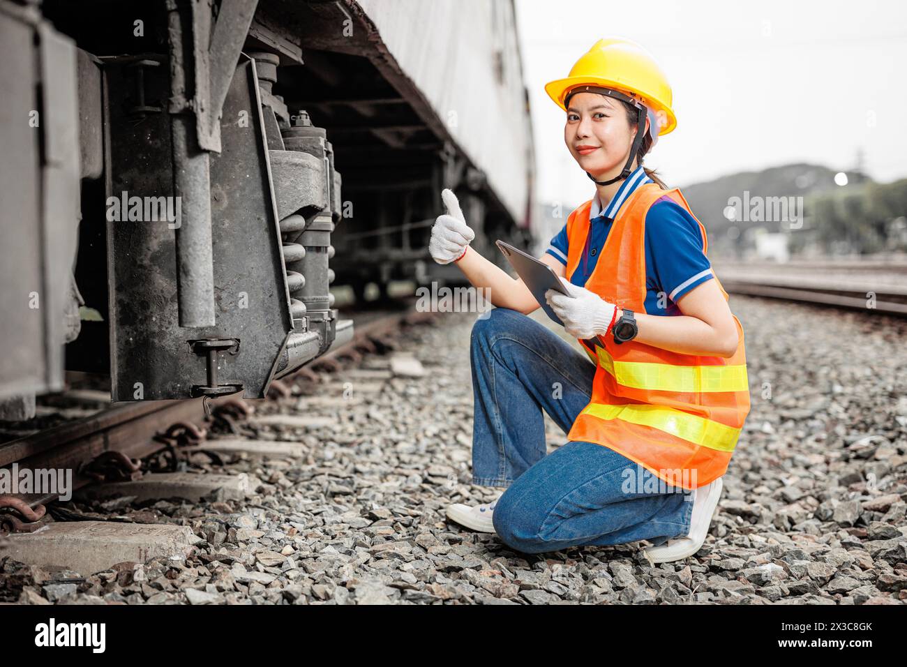 Glückliche Ingenieurinnen, Arbeiterin, Wartung Wartung, Zug, Radaufhängung bestätigen, dass Daumen hoch in gutem Zustand sind Stockfoto