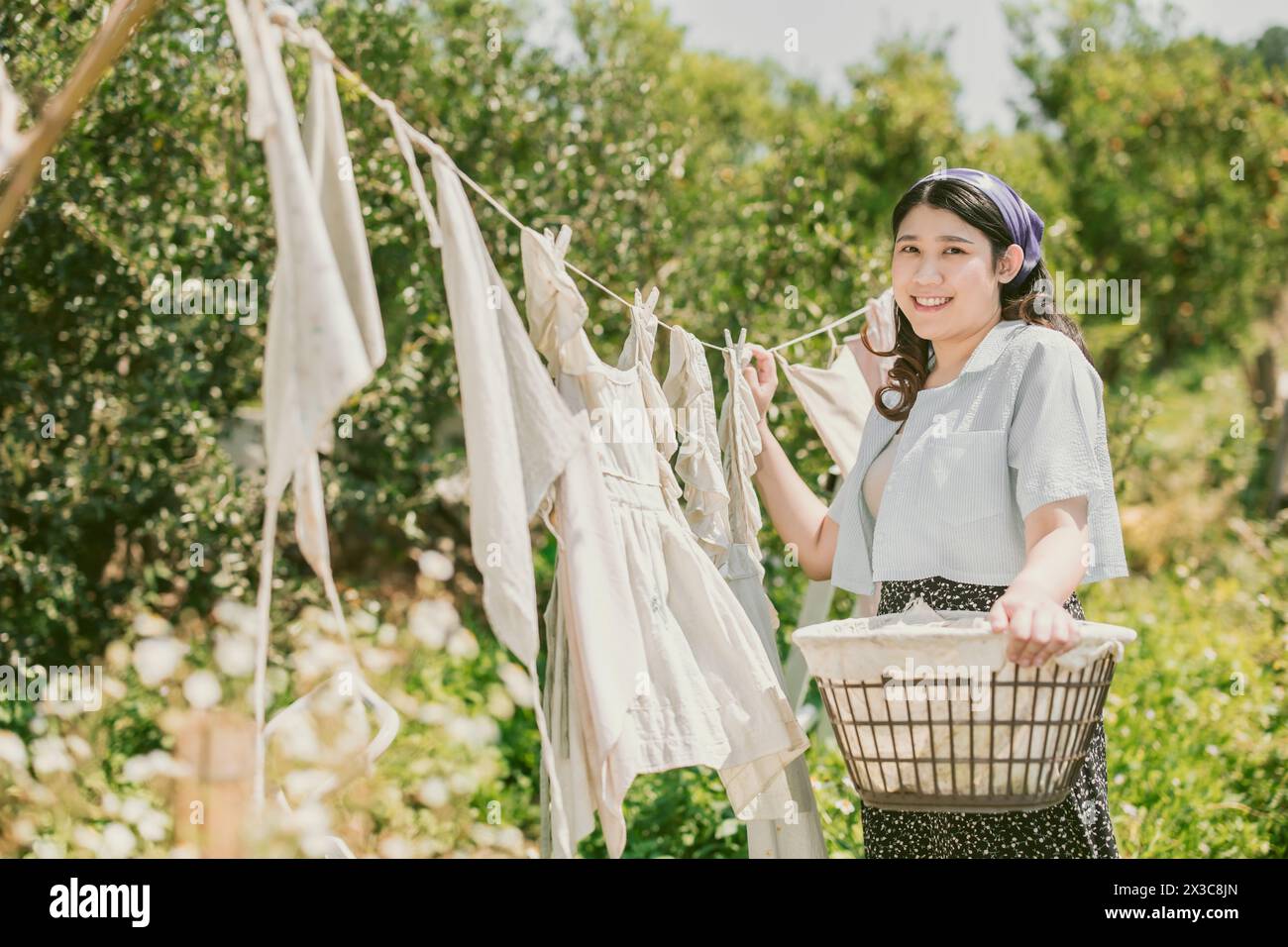 Ländliche Bauernhof Mädchen Volksfrauen Dienstmädchen Hausfrau trocknende Kleidung im Freien Vintage Retro Stil Landleute. Stockfoto