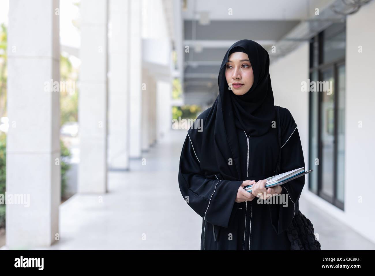 Universität saudi-arabische Niqab-Frau High Education im Universitätscampusgebäude mit modernen Wissensbüchern. Arabisch-saudische schwarze Chador-Teenager-Dame. Stockfoto