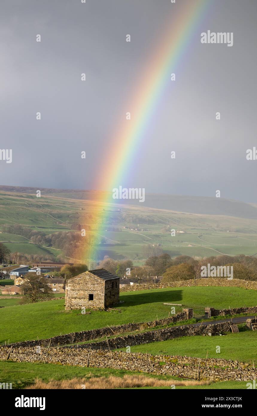 Alte Steinscheune in den Yorkshire Dales am Ende eines Regenbogens während eines Frühlingsschauer. Hawes, North Yorkshire, Großbritannien Stockfoto