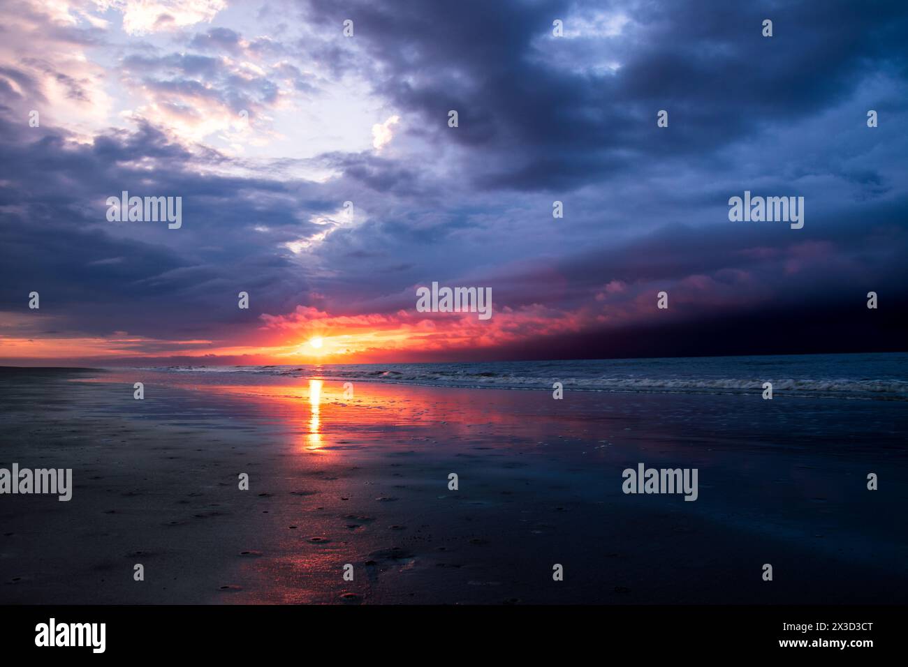 Stürmischer Sonnenaufgang über dem Meeresstrand. Stockfoto
