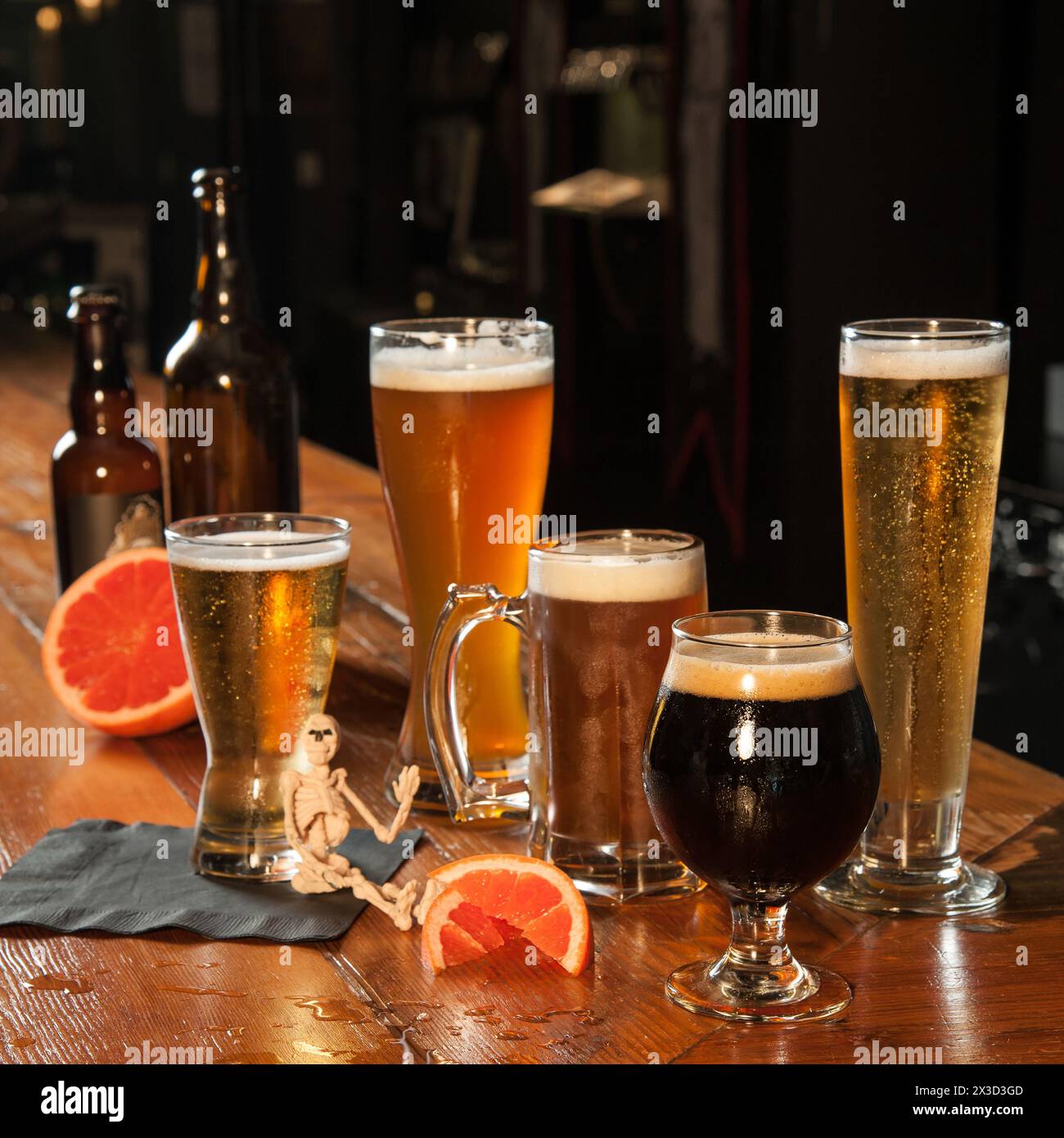 Eine Auswahl an Bieren mit Zitrusgarnitur in einer dunklen Holzbar Stockfoto