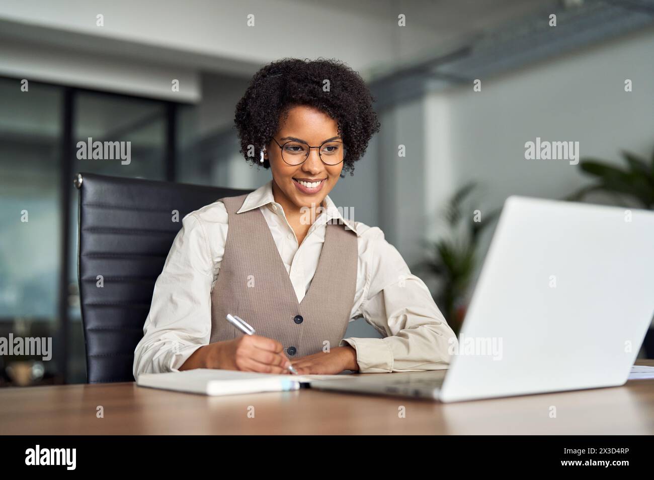 Glückliche junge afrikanische Geschäftsfrau, die ein Hybrid-Büro-Meeting-Videoanruf hat. Stockfoto
