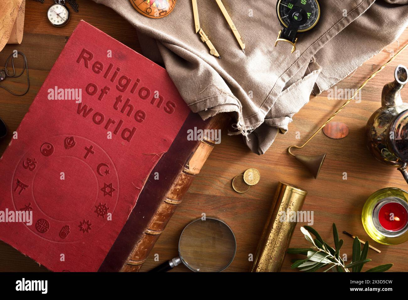 Allgemeine Ansicht des alten und verschlechterten Buches der Religionen der Welt mit eingravierten Buchstaben und religiösen Symbolen verschiedener Religionen auf dem Umschlag Stockfoto