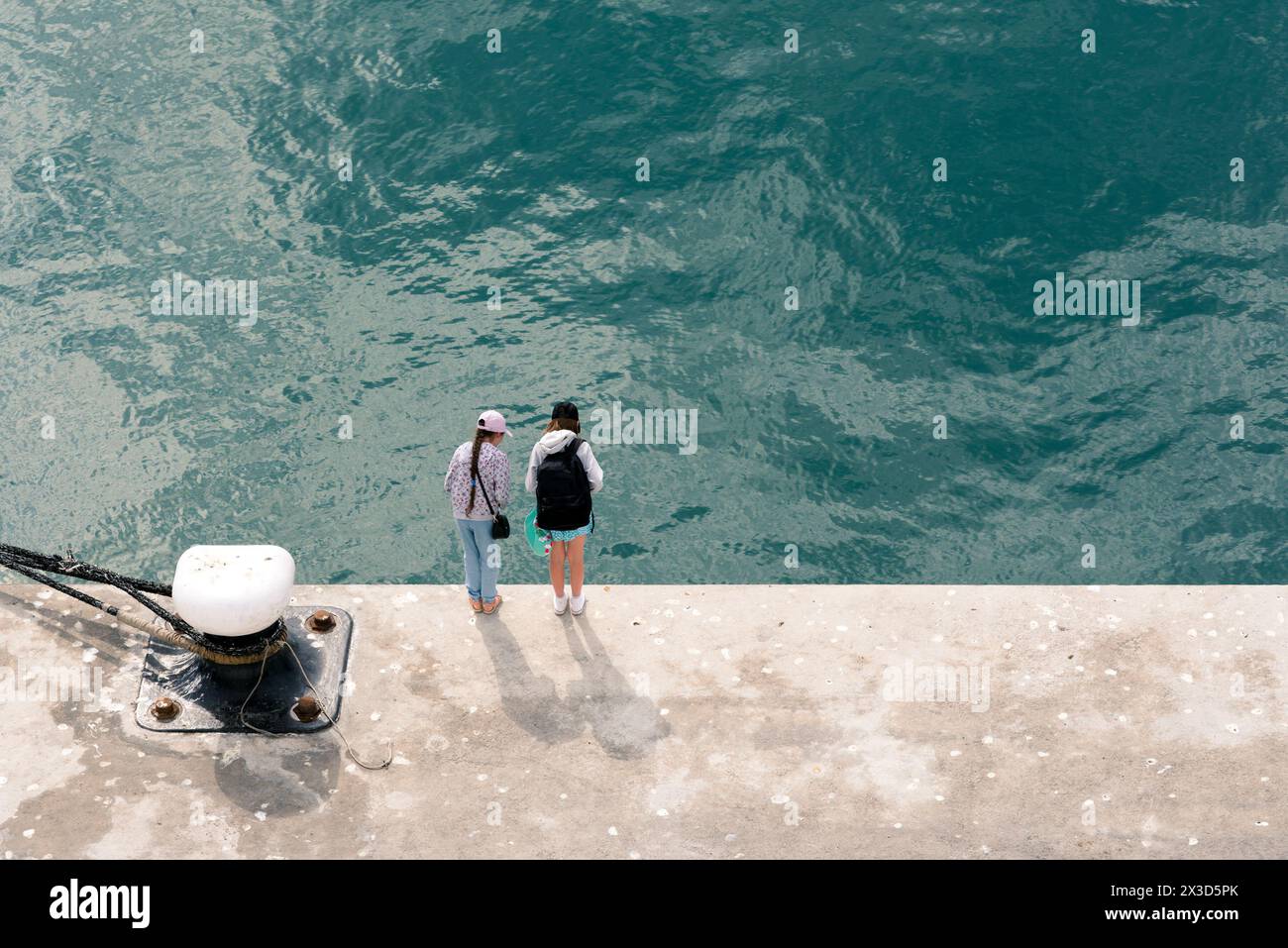 Zwei kleine Mädchen schauen über den Damm ins Wasser Stockfoto