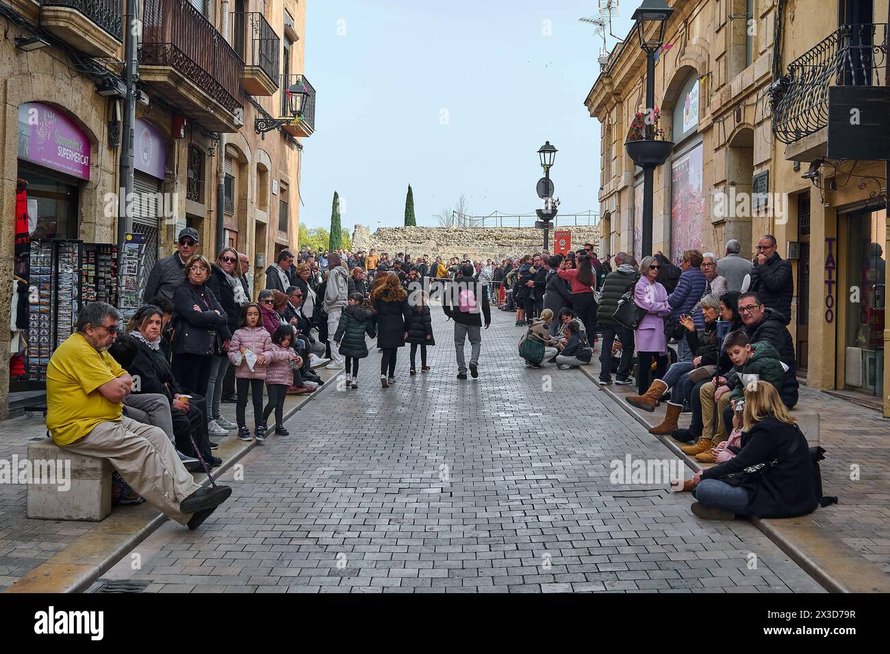 Tarragona, Spanien - 26. April 2024: Szene der Karwoche in einer historischen Straße in Tarragona, wo Einheimische und Besucher die festliche Atmosphäre mit alten Menschen genießen Stockfoto