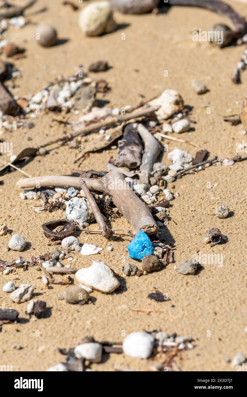 Ein kleines Stück blaues Plastik, das mit Bimssteinen und Treibholz am Mission Beach in Far North Queensland, Australien, gespült wurde Stockfoto