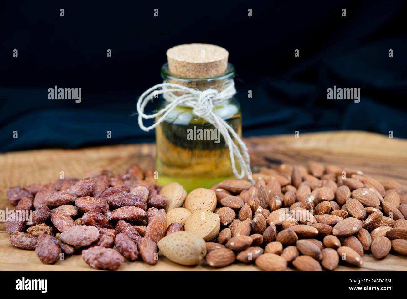 Mandel (Prunus dulcis, Prunus amygdalus, Amygdalus communis, Amygdalus dulcis), geröstete Mandeln, mit Schale und rohem Mandelöl Stockfoto