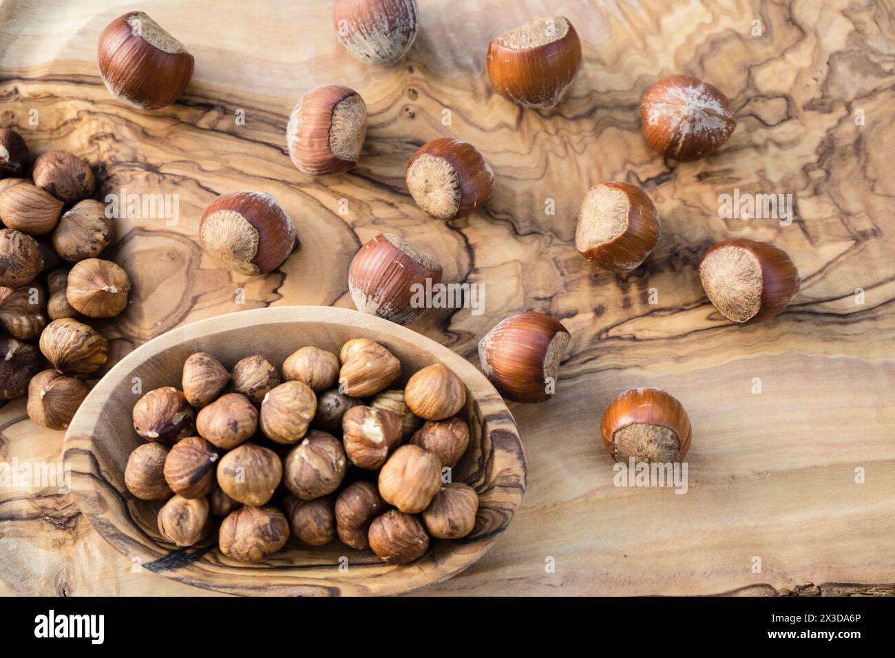 Haselnuss (Corylus avellana), Haselnüsse, ganz und zerrissen, in einer Schüssel Stockfoto