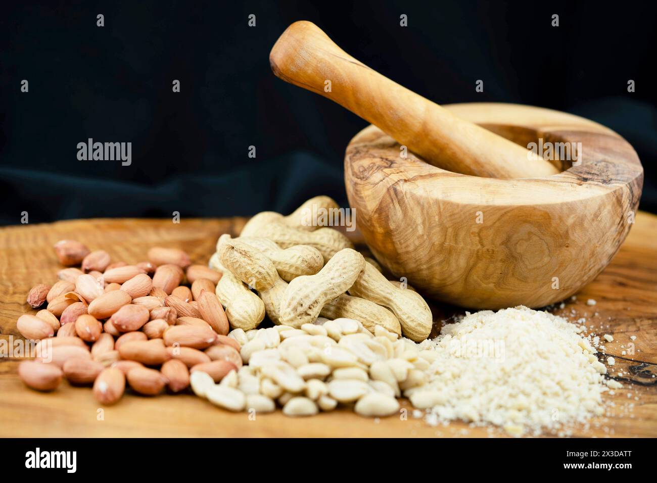 Erdnuss, Erdnuss (Arachis hypogaea), Erdnüsse mit und ohne Schale, geschält und gehackt, mit Mörtel Stockfoto